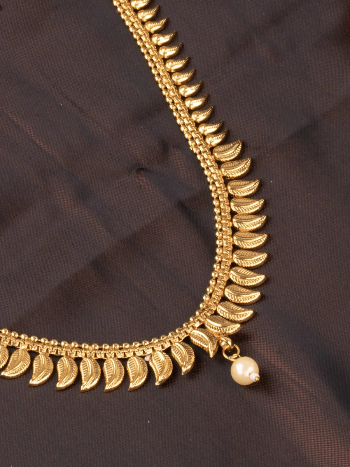 Tarani closeup view of gold plated necklace set showing pearl detailing for festive occasions