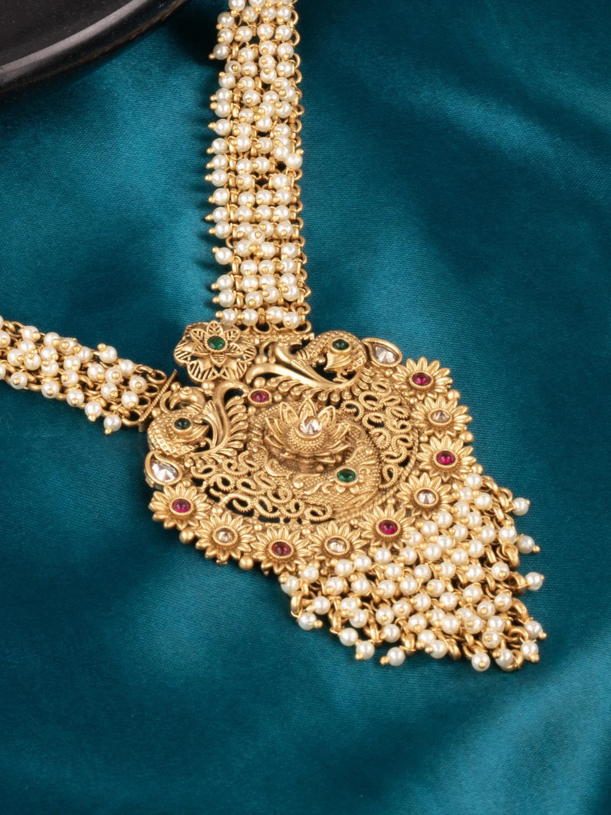 Tarani closeup view of gold necklace set with antique work and pearls