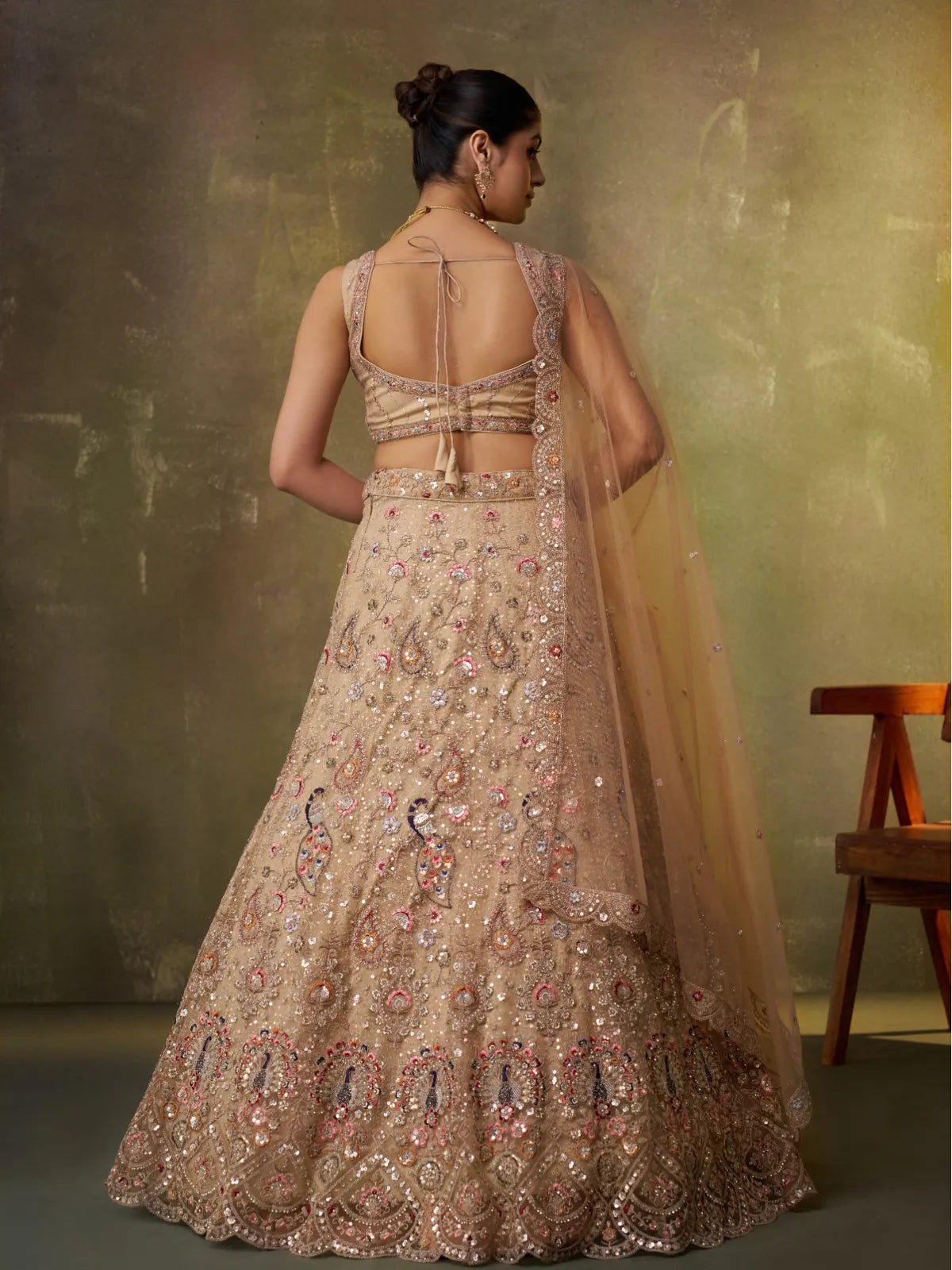 Tarani beige lehenga back view featuring tied blouse back and embroidered skirt