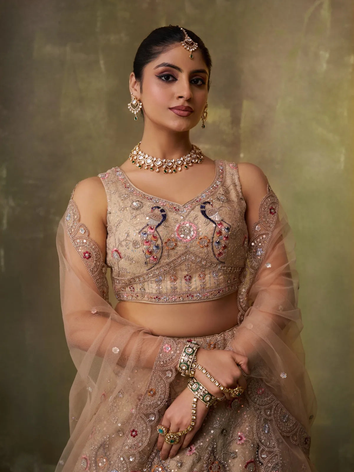Tarani beige net lehenga upper body view showing sweetheart neck blouse with sequin work