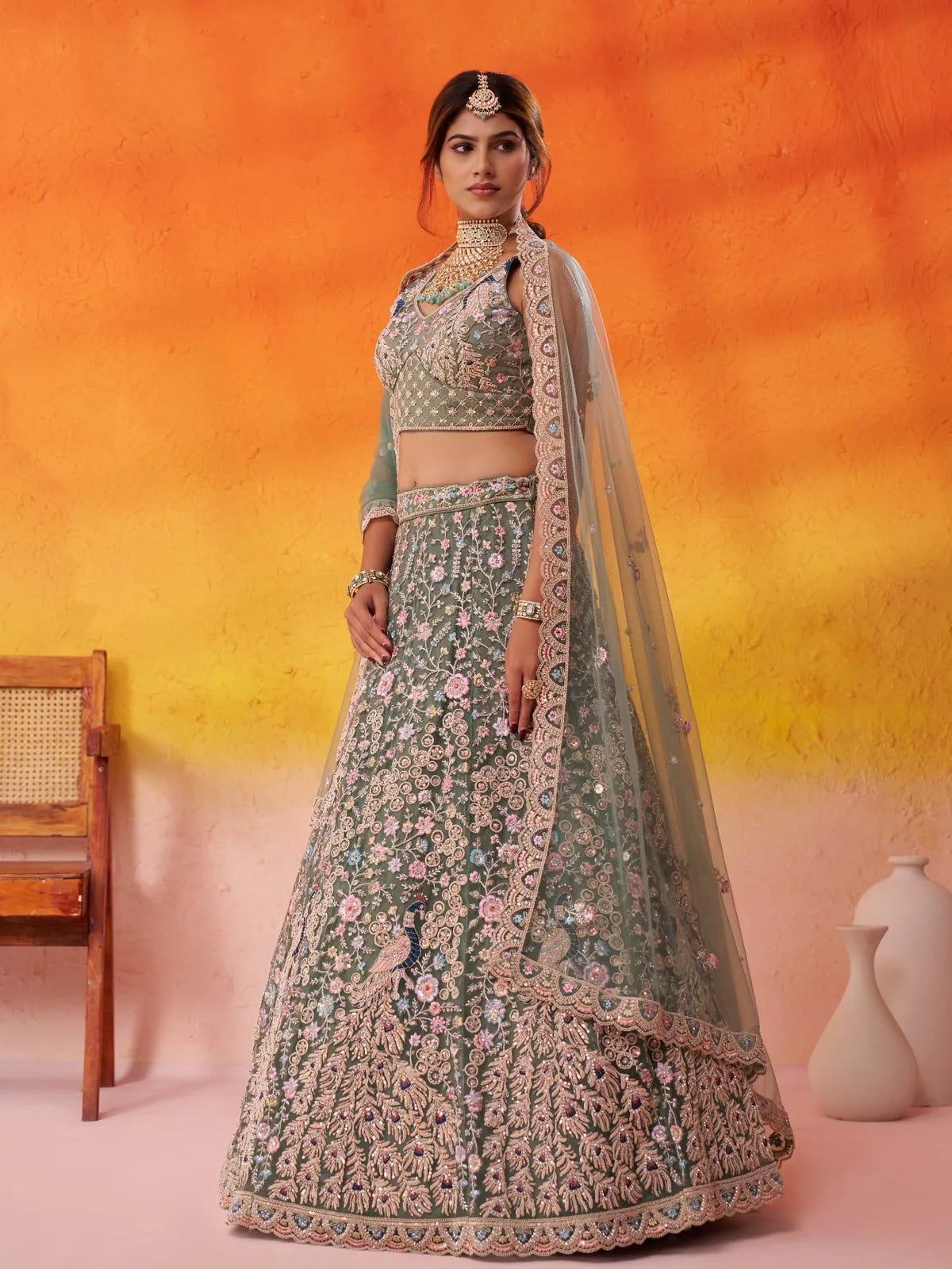 Front pose of Tarani green net lehenga with dupatta draped elegantly