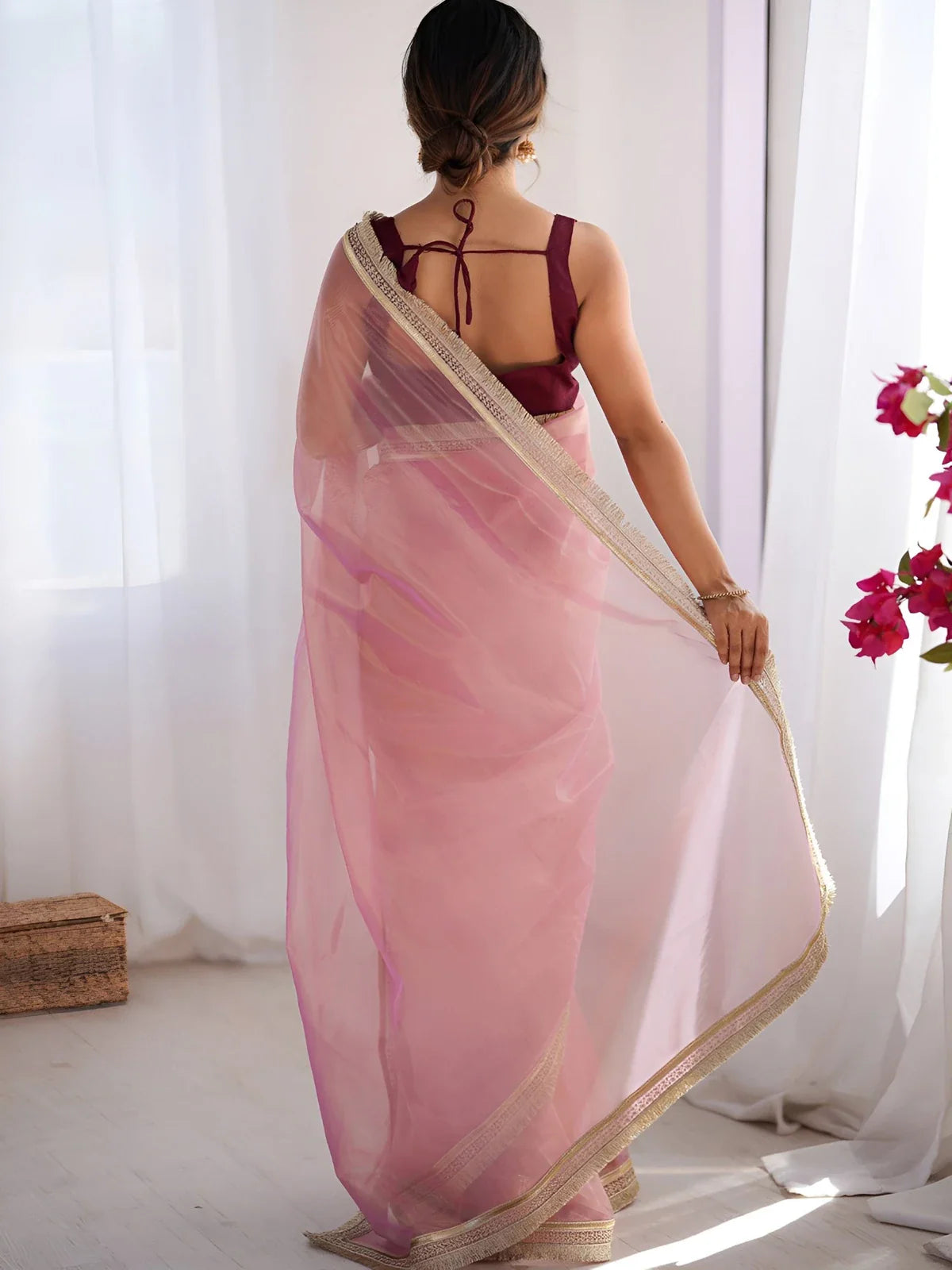 Tarani back view of sheer pink net saree with shimmer border and tied blouse