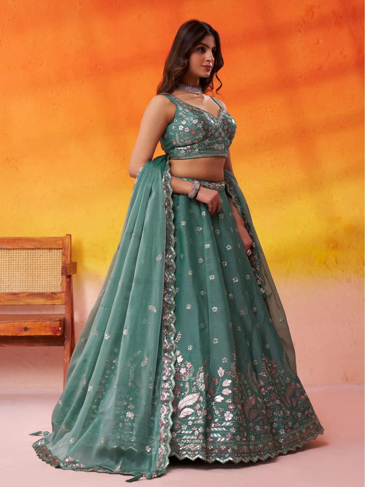 Tarani side profile of green lehenga in organza with floral embroidery and heavy flare