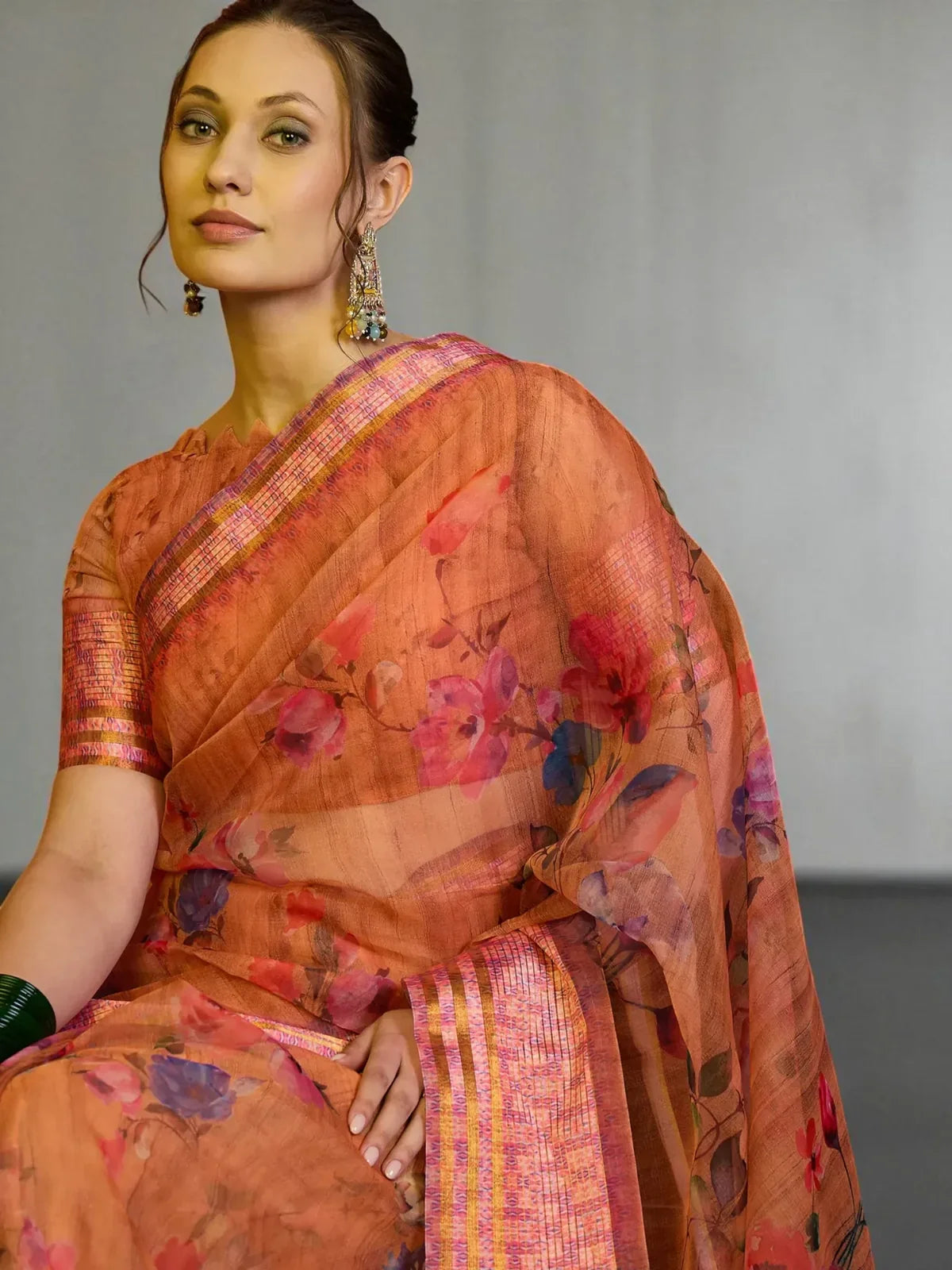 Tarani organza orange saree closeup showing floral print and designer pallu