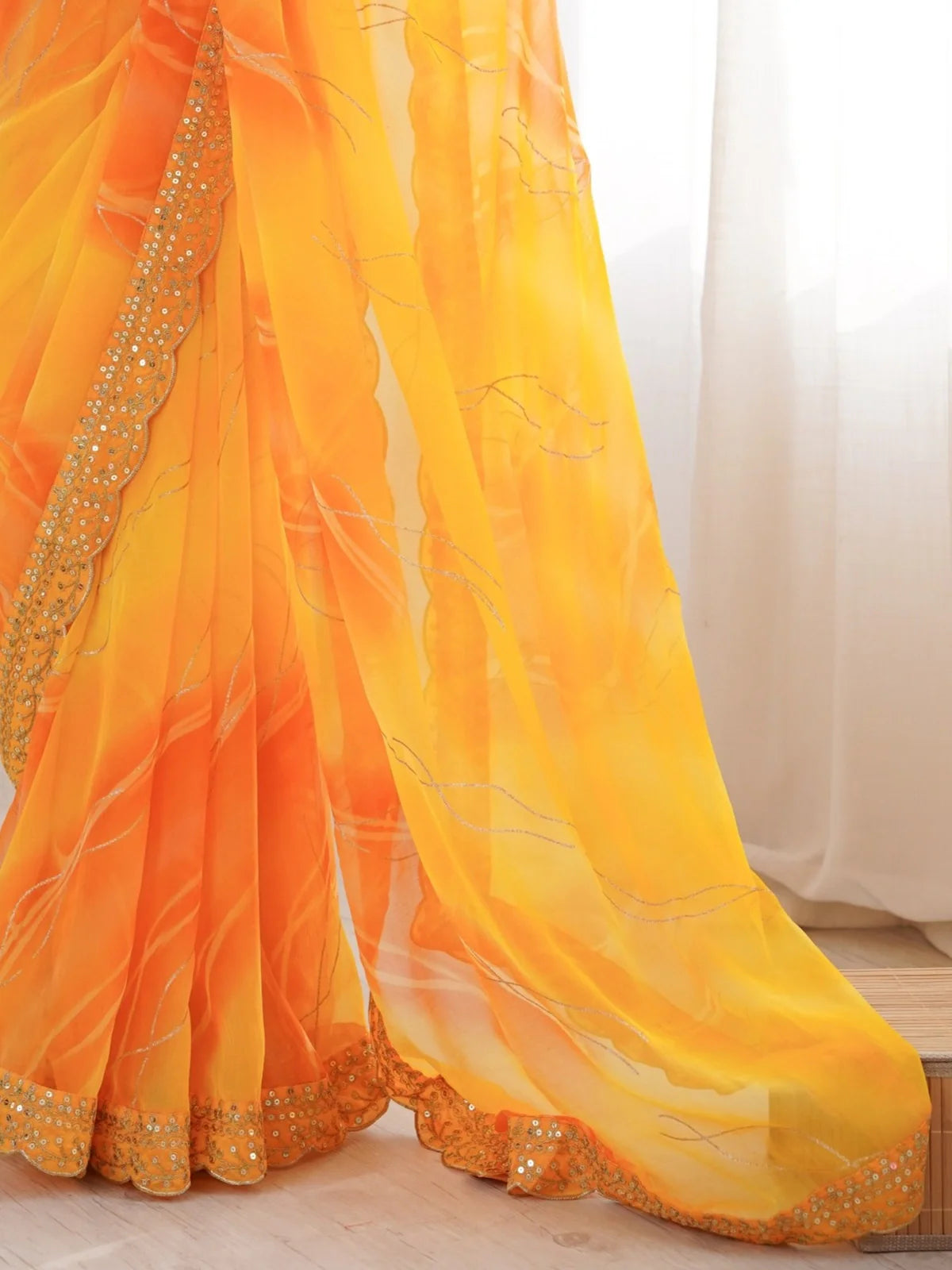 Tarani saree close-up showing lahariya gold foil detailing on yellow orange chiffon