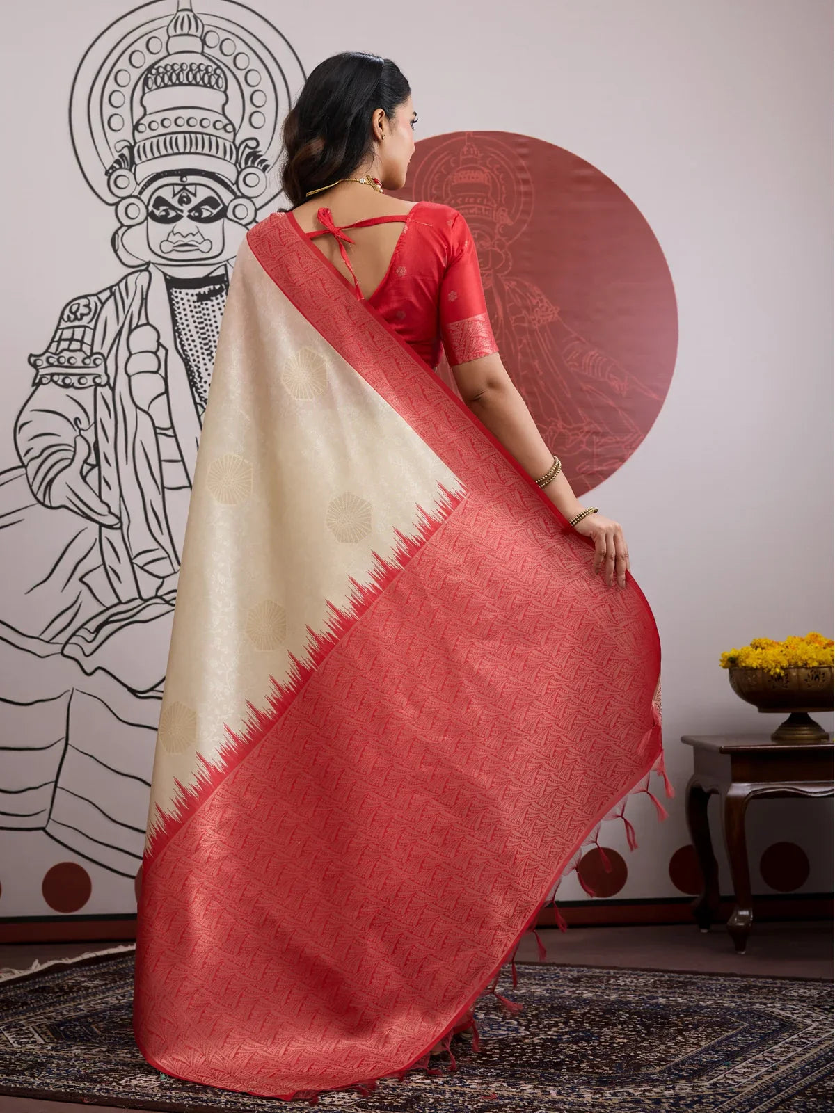 Tarani saree draped from the back featuring beige fabric with red pallu and tie-up blouse