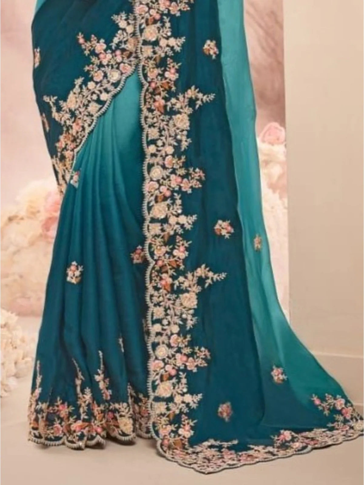 Tarani green saree pallu close-up with rich embroidery and floral lace border