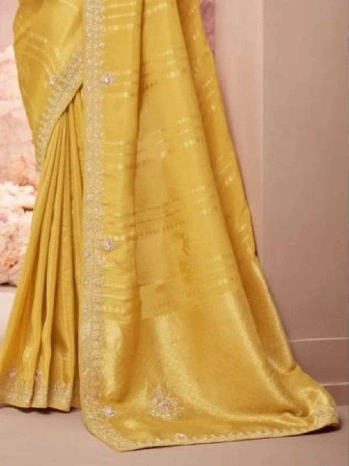 Tarani closeup of yellow designer saree fabric with soft sheen and handwork detailing