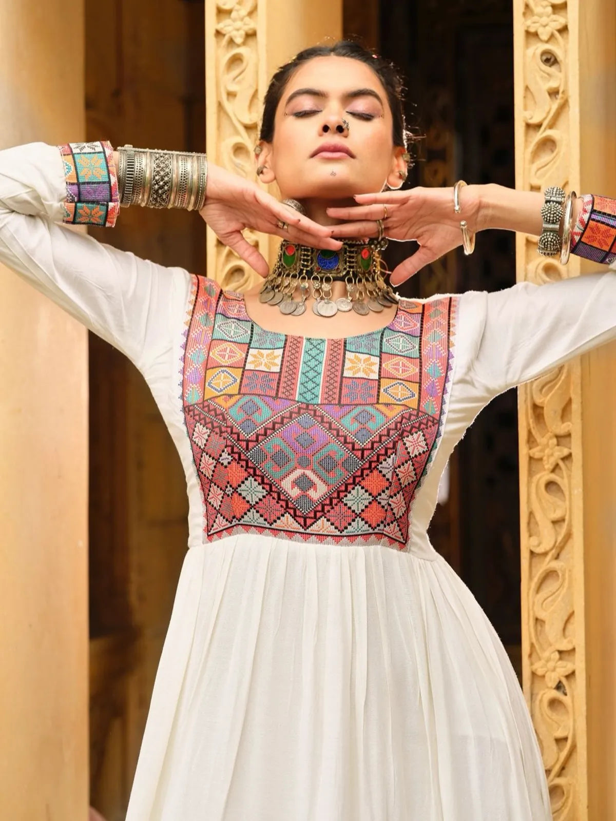 Tarani designer white rayon gown with detailed neckline and sleeve embroidery in close-up