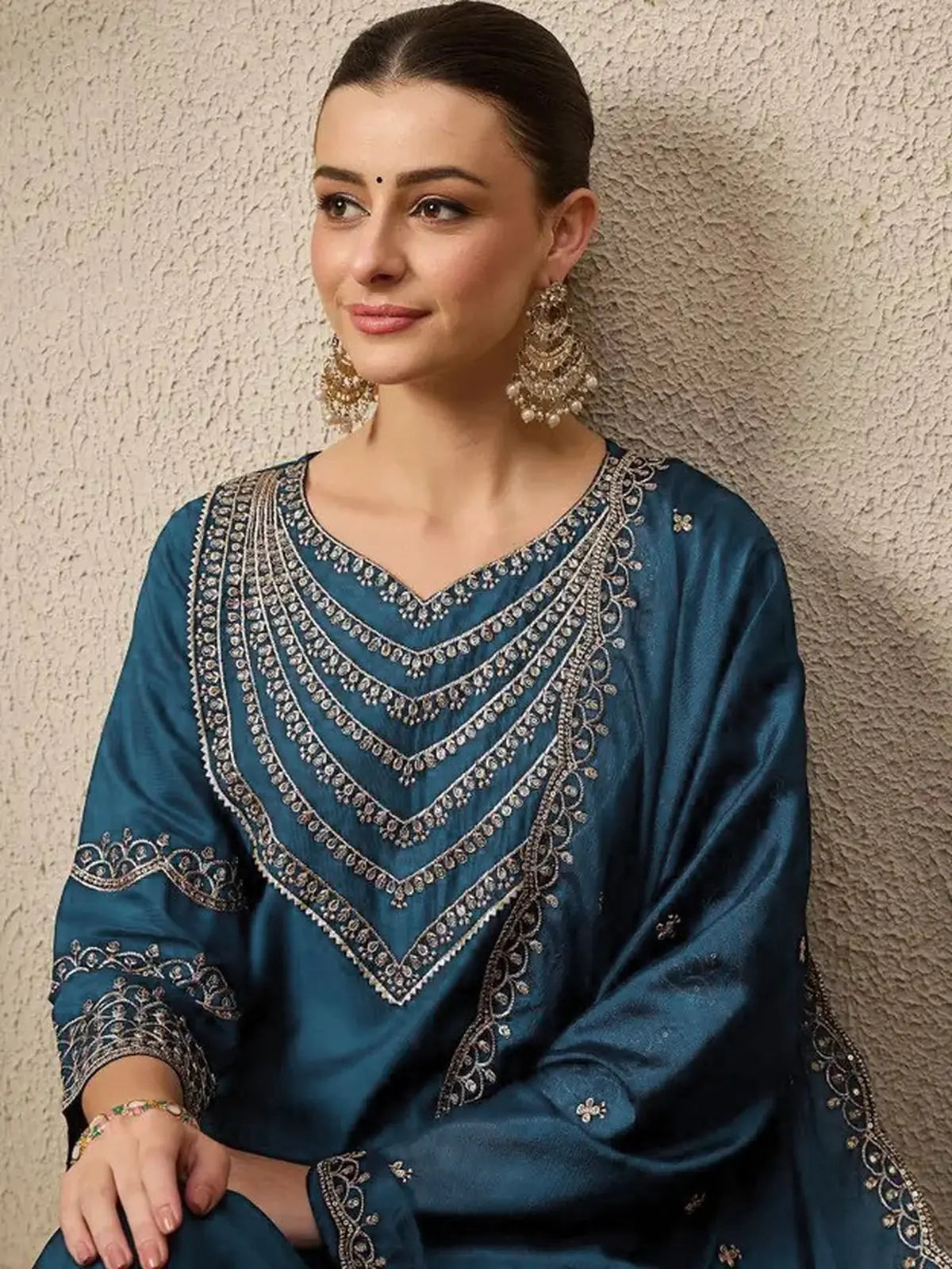 Tarani Roman dress upper body close-up showing embroidered neckline and earrings