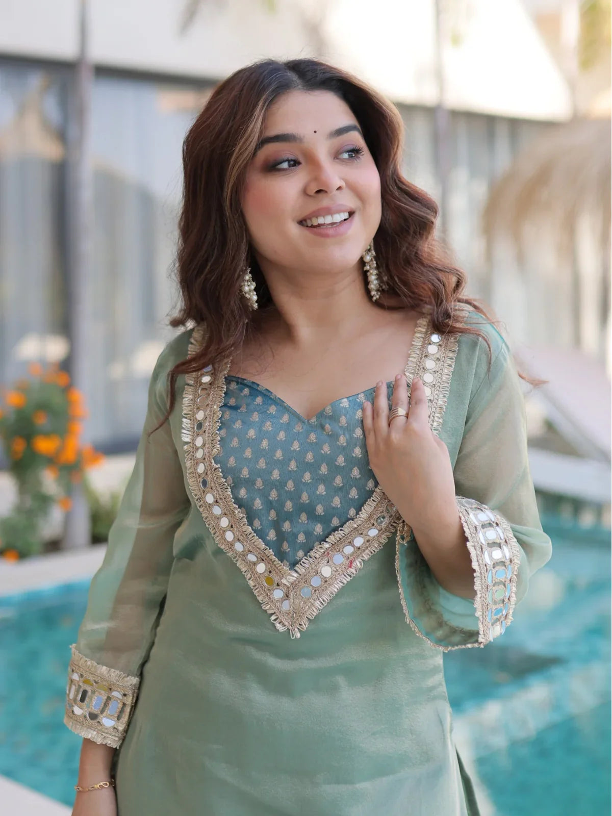 Tarani festive green salasa dress showing detailed neckline mirror embroidery in upper body pose