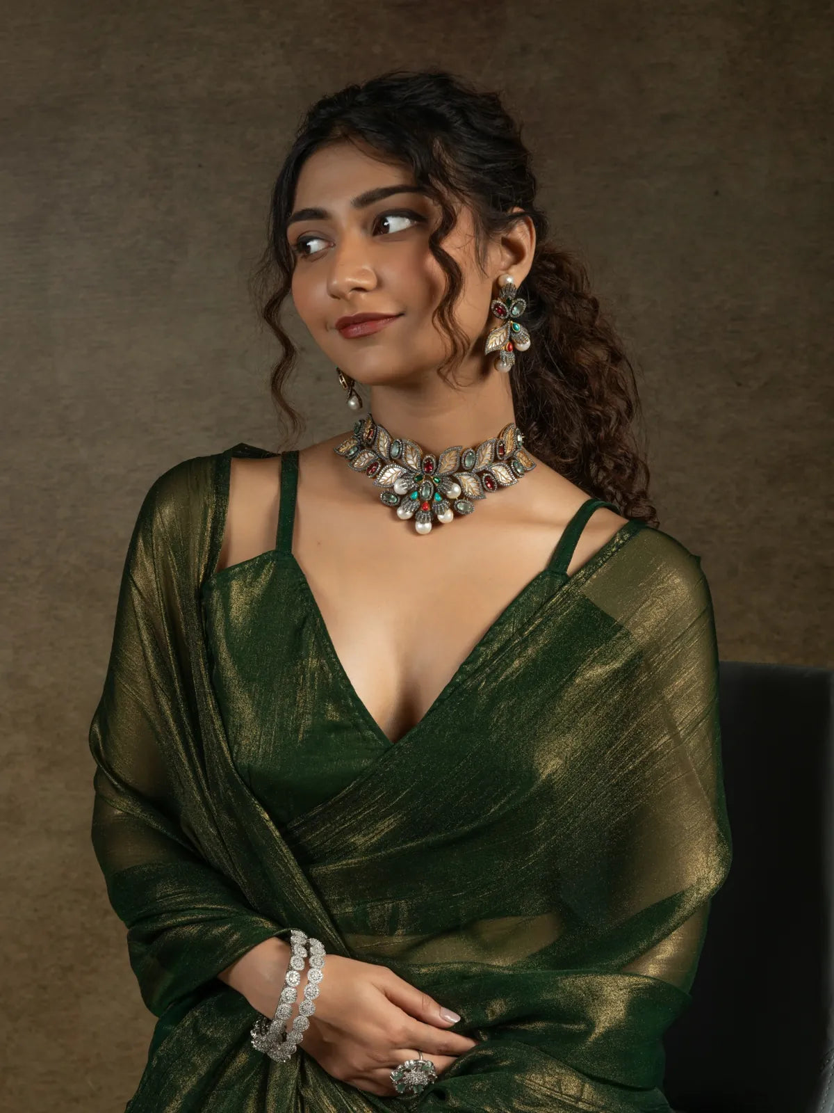 Tarani satin chiffon green saree closeup showing blouse design and jewelry styling