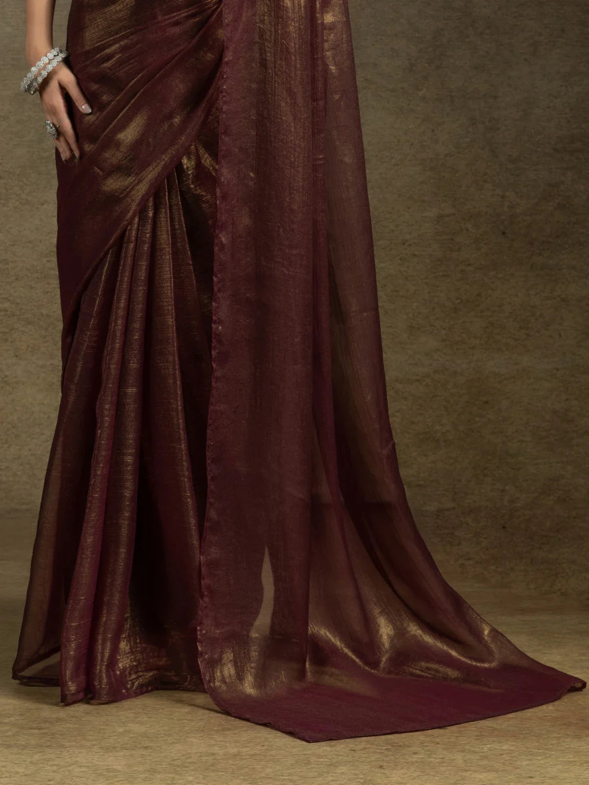 Tarani maroon satin chiffon saree with golden pallu flow and pleats drape close-up