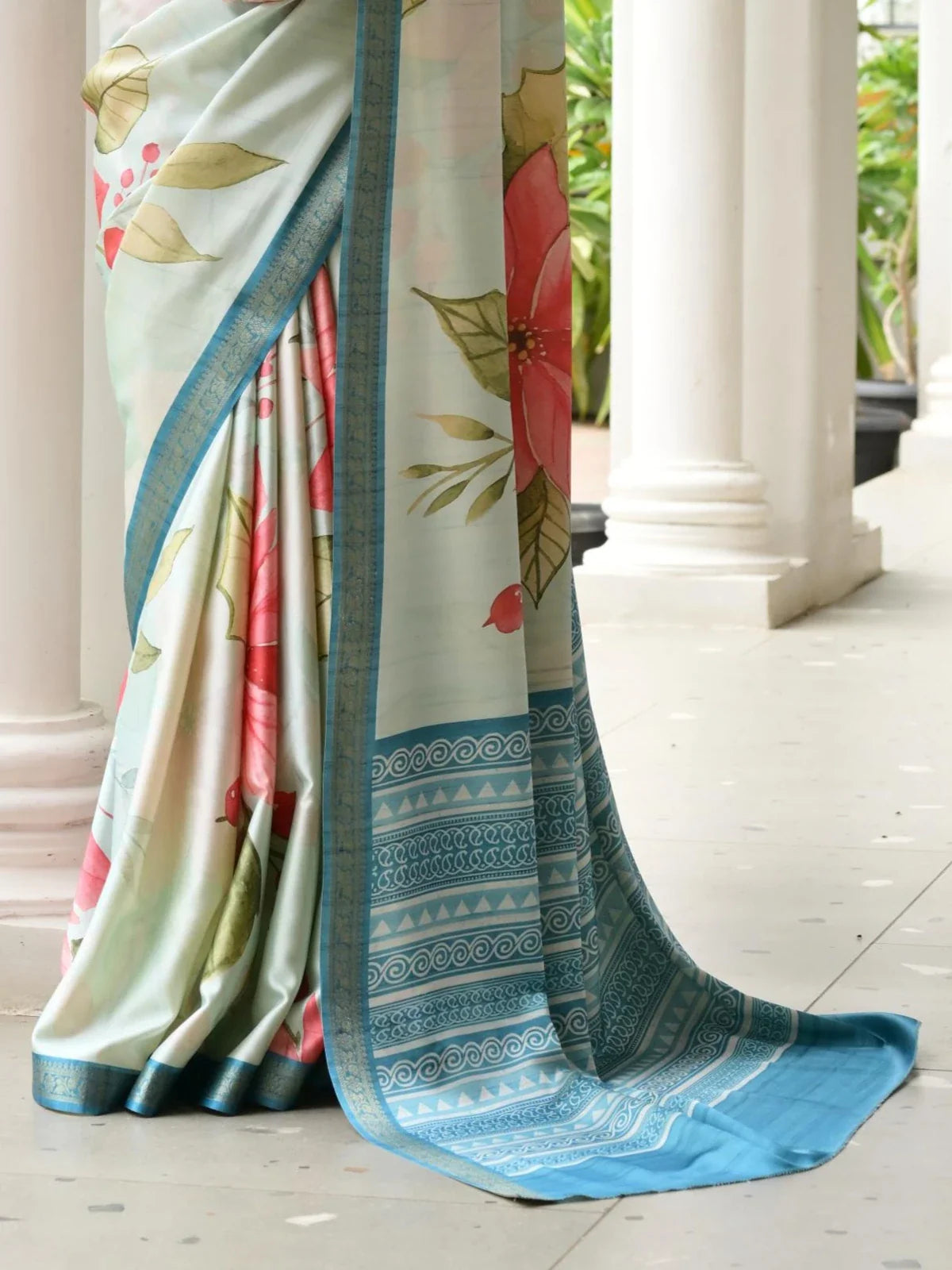 Tarani satin saree closeup showing floral hand painted detailing and blue zari border