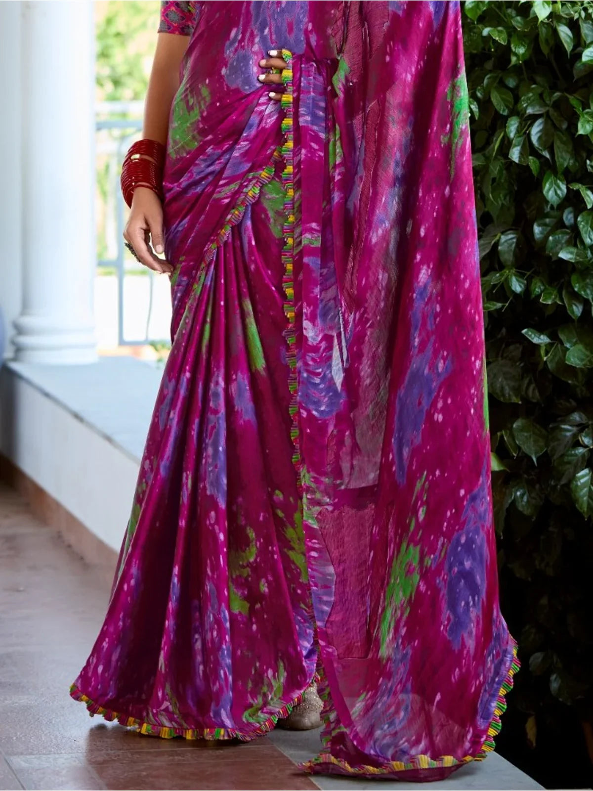 Close-up view of Tarani magenta satin saree showing pallu detailing and fabric texture