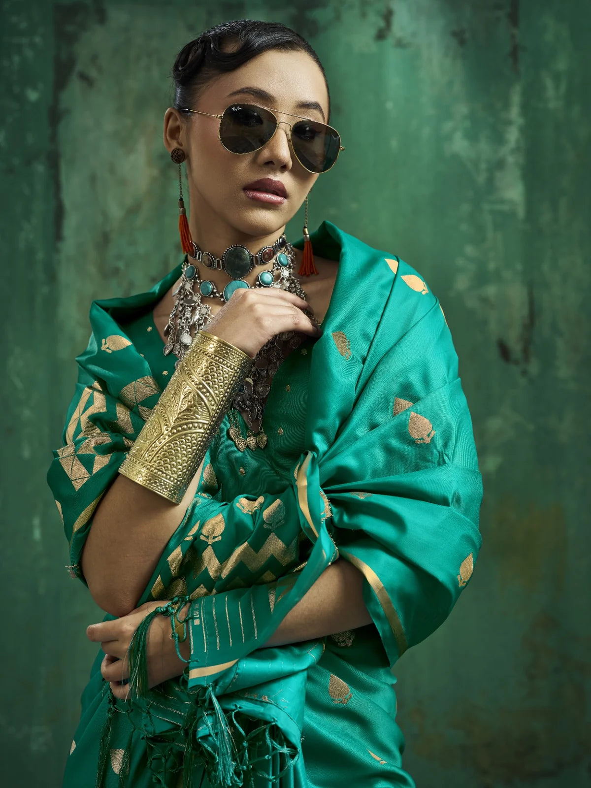 Tarani teal green saree closeup showing rich satin texture woven border and graceful drape