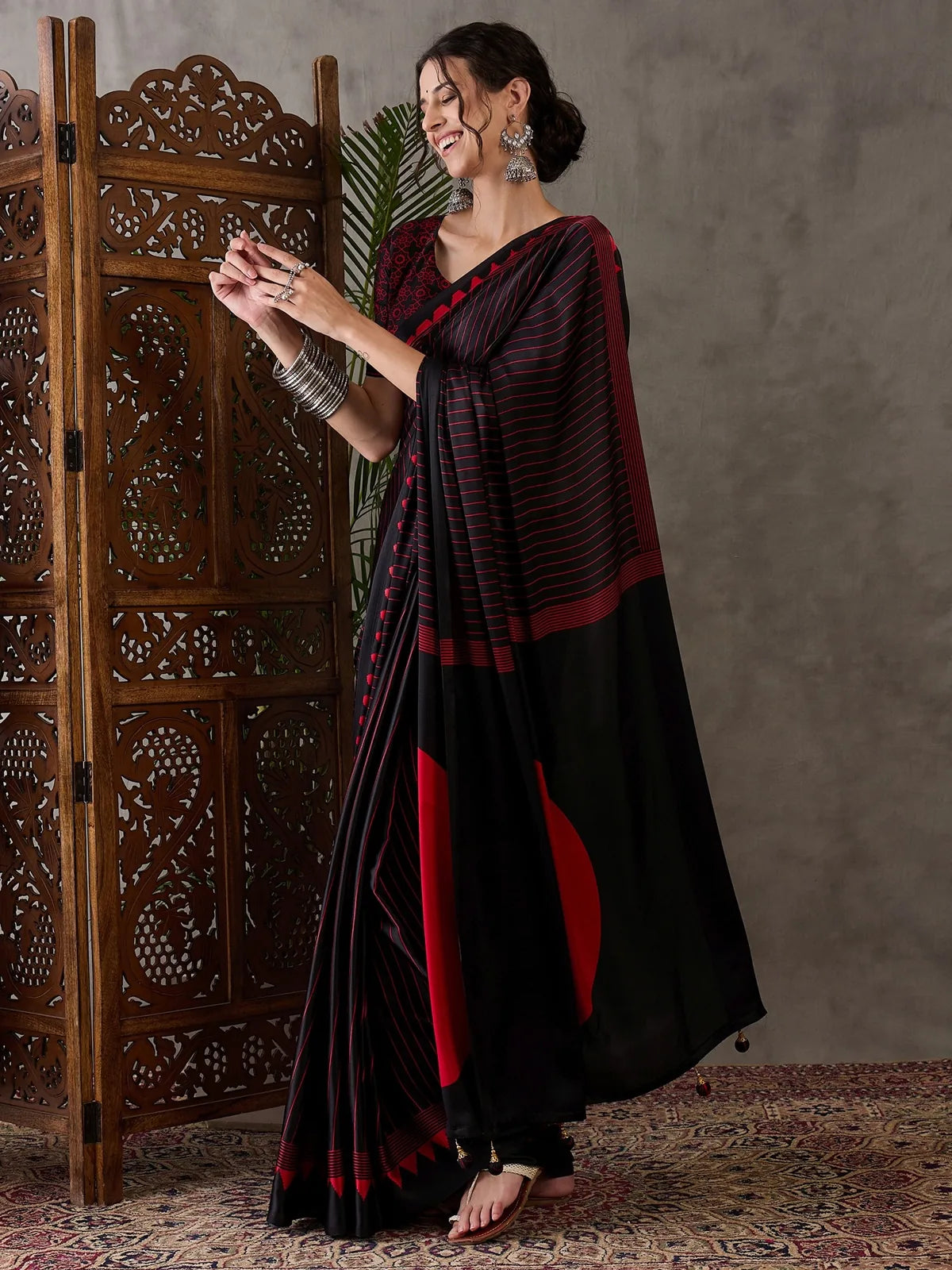Tarani Rajvi side pose black semi modal satin party wear saree with printed blouse