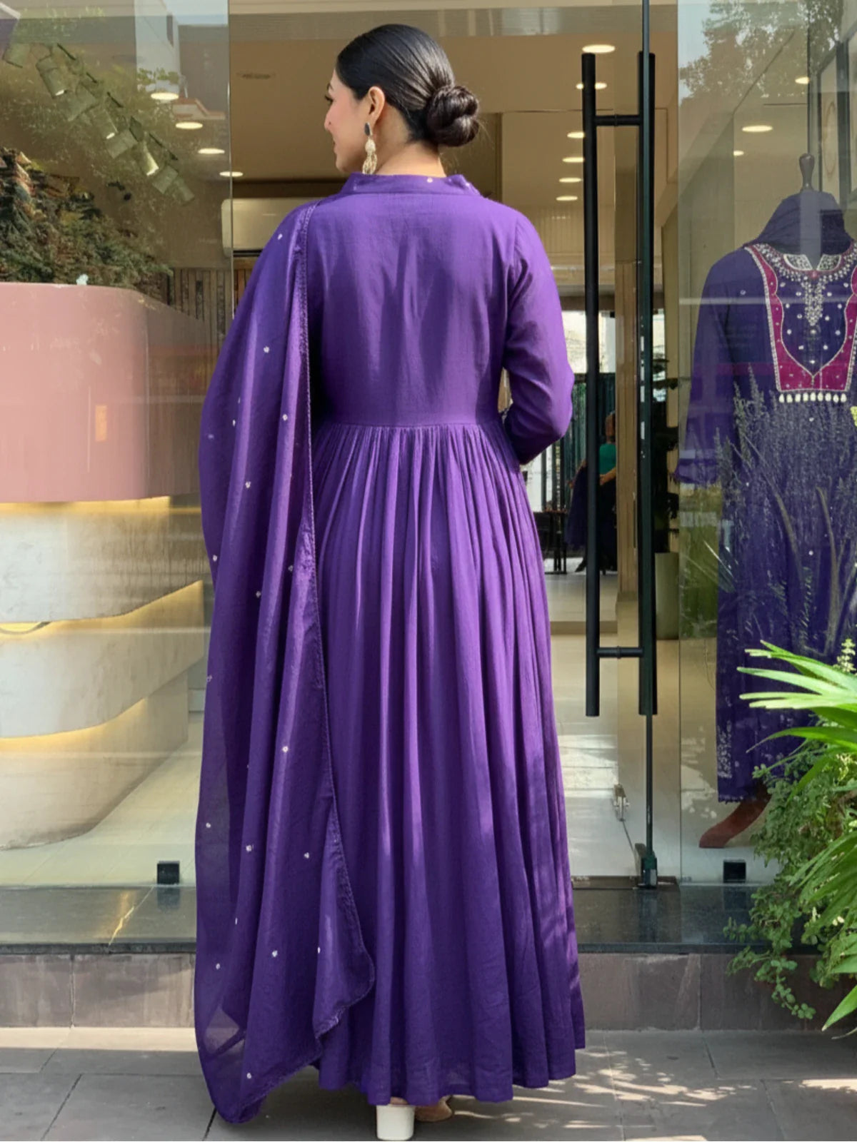 Tarani back view of purple silk dress with flared design and plain back profile