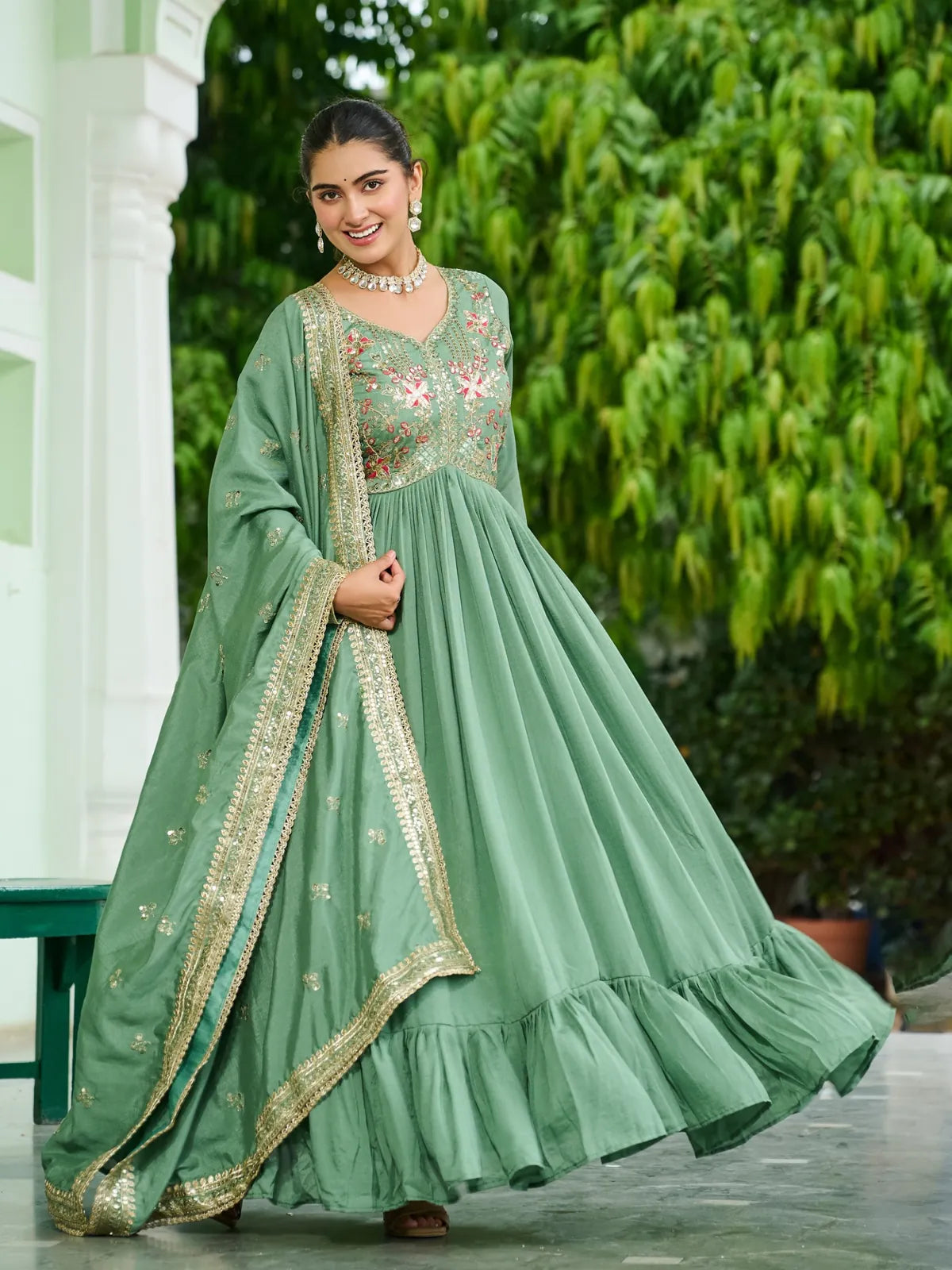 Front angle view of Tarani embroidered green gown with dupatta flow and full flair