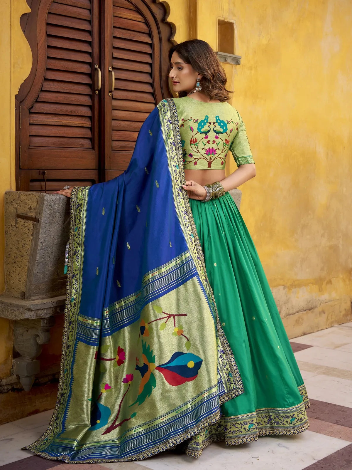 Tarani lehenga back view showing peacock embroidery blouse and blue pallu with lace