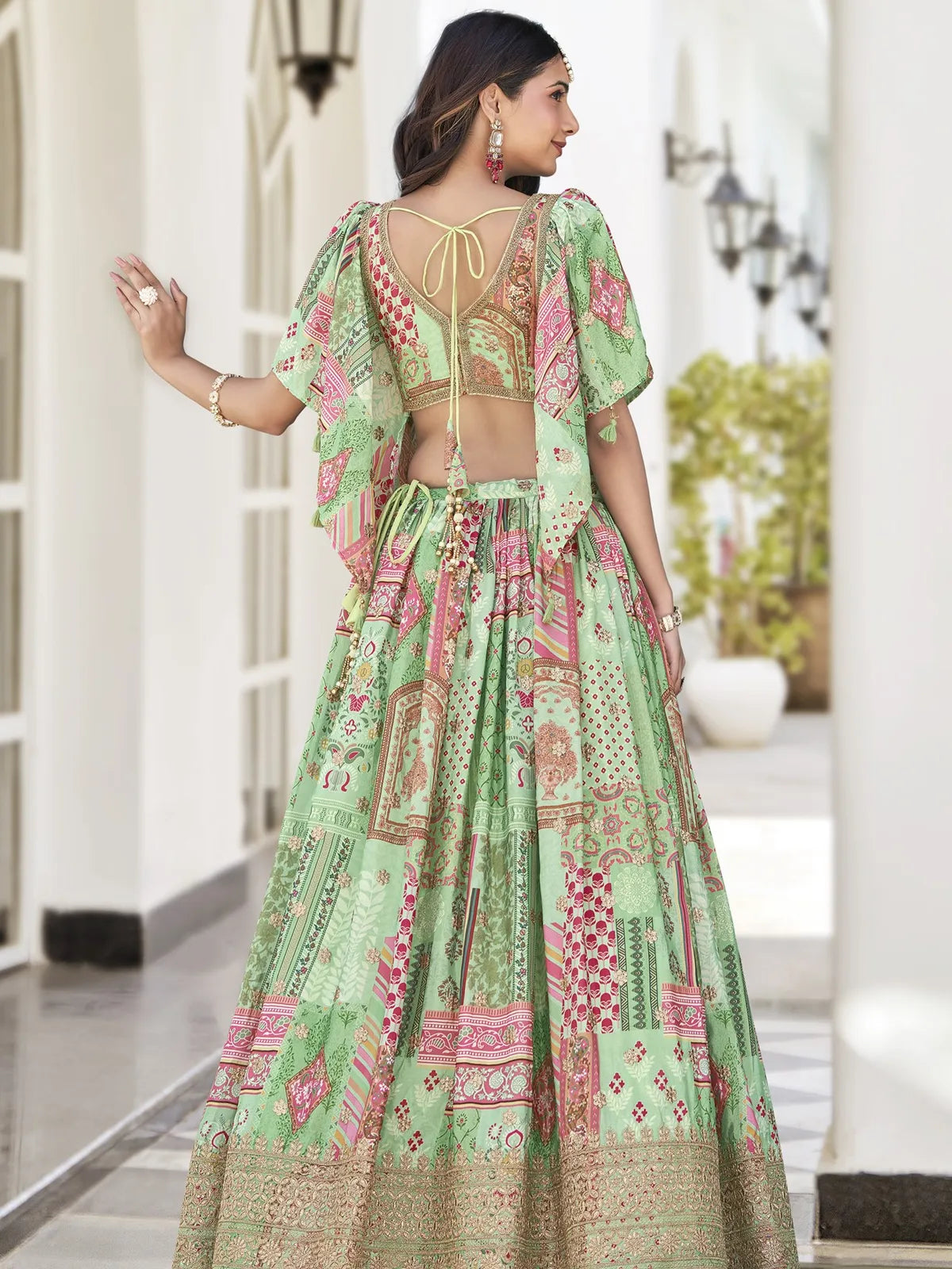 Tarani green silk lehenga back pose with tassel tie blouse and flare design