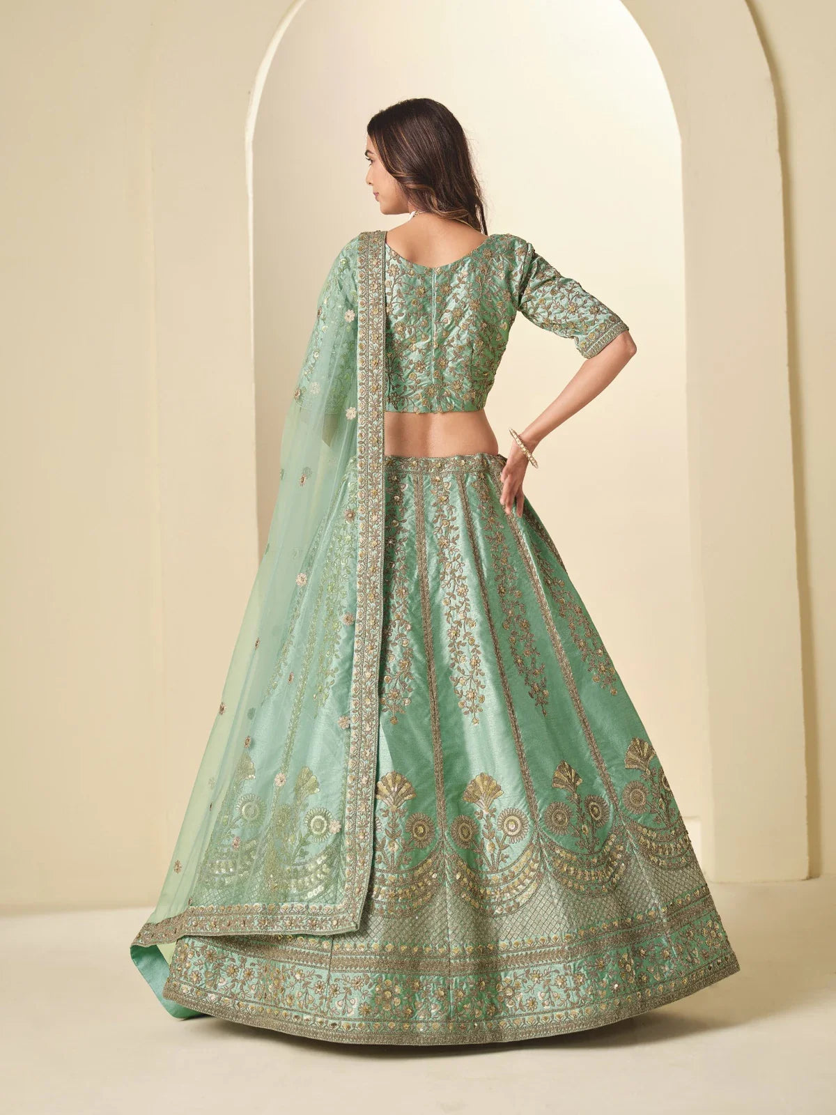 Tarani designer lehenga back view showing embroidery and flare in green silk