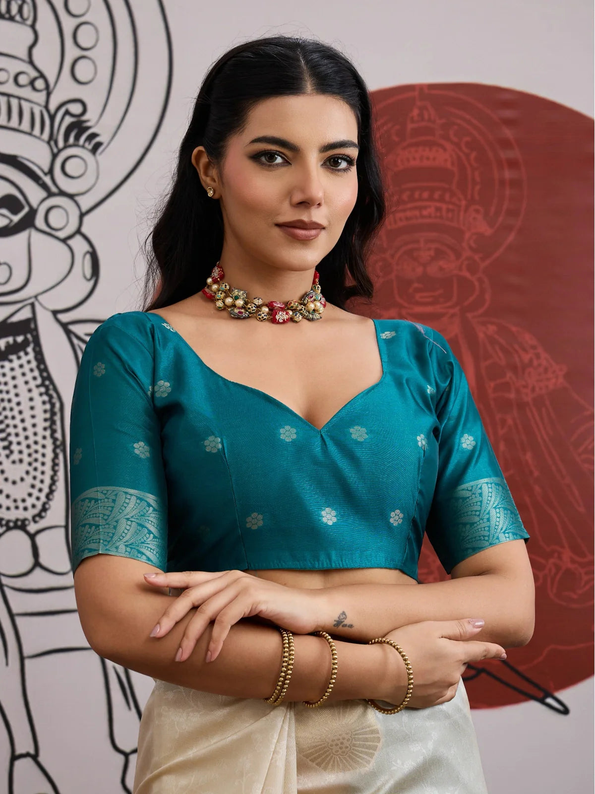 Tarani close-up of model in beige paper silk saree with teal green stitched blouse and jewelry