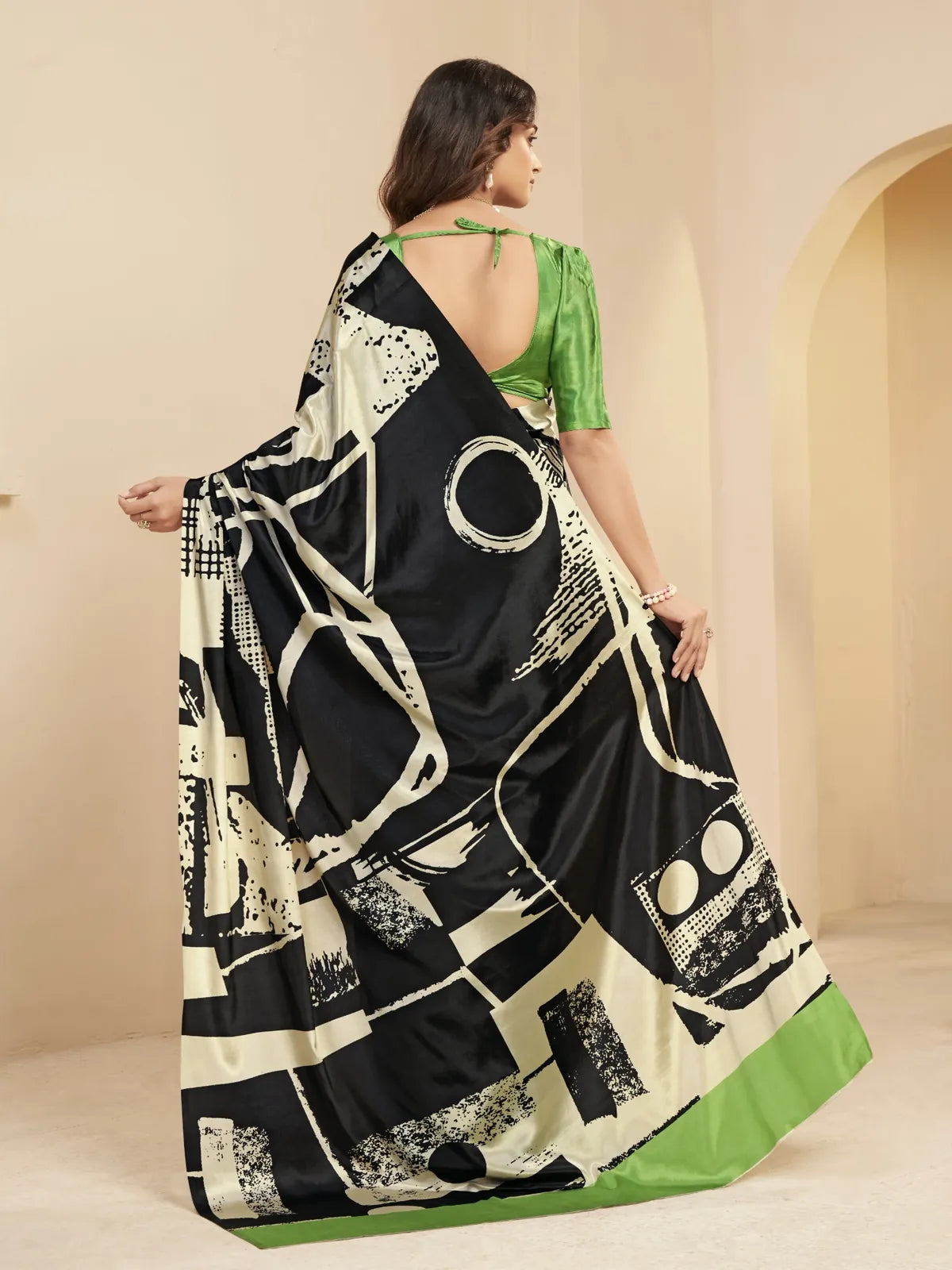 Tarani black printed saree back view with green silk deep cut blouse