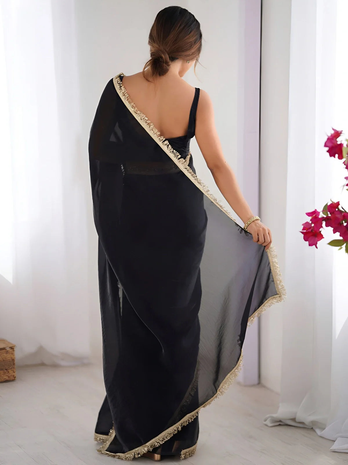 Tarani back view of black soft silk saree showing full pallu flow and lace detailing