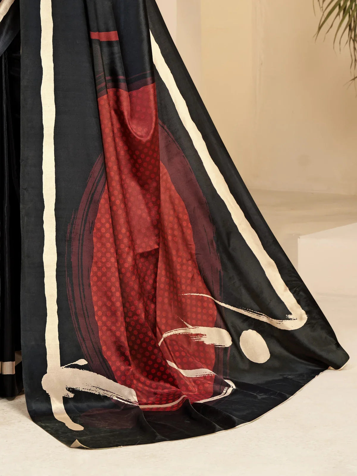 Tarani black silk saree closeup showing red pallu digital print and textured detailing