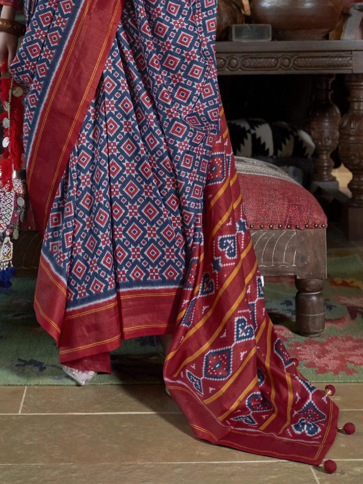 Tarani pallu view of designer ikkat blue silk saree with red border and tassel detailing