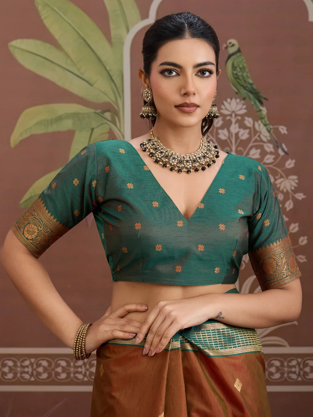 Tarani premium silk saree close-up showing deep green blouse with zari sleeve and floral motifs
