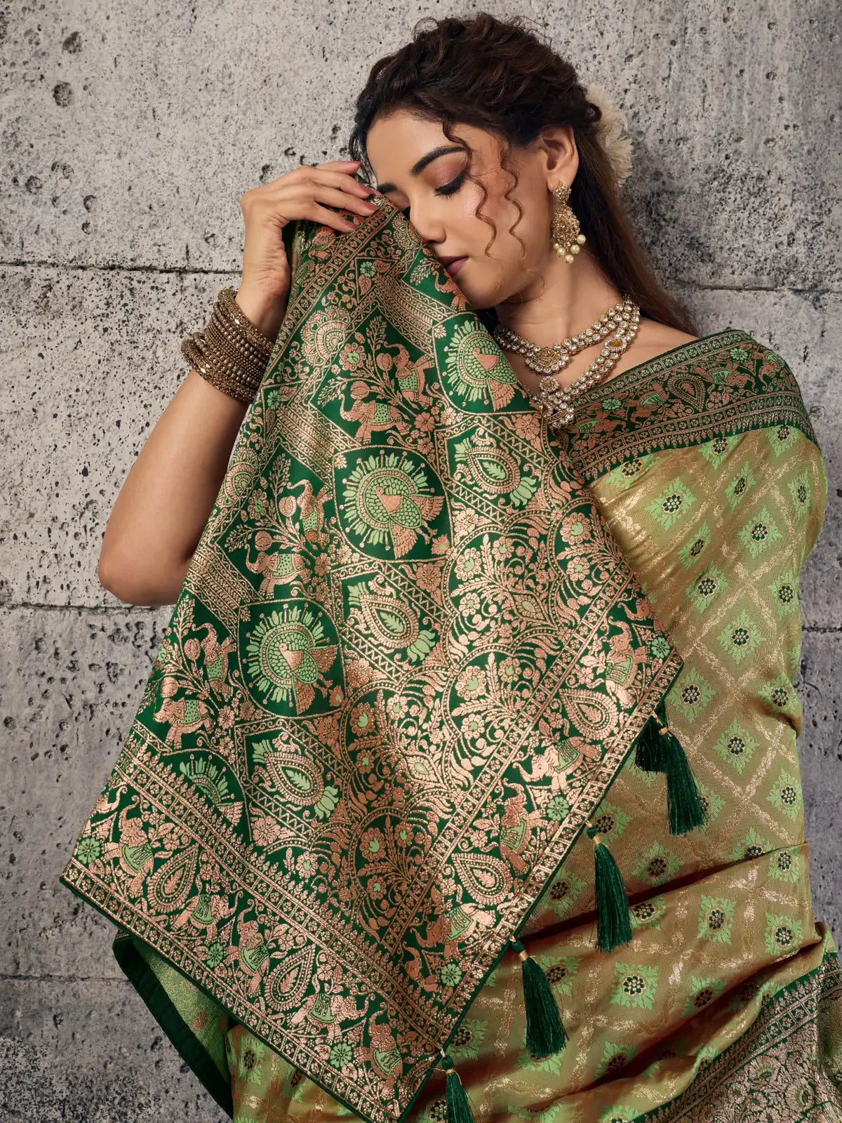 Tarani rich green Banarasi self embossed silk saree closeup of grand woven pallu zari motifs and tassels