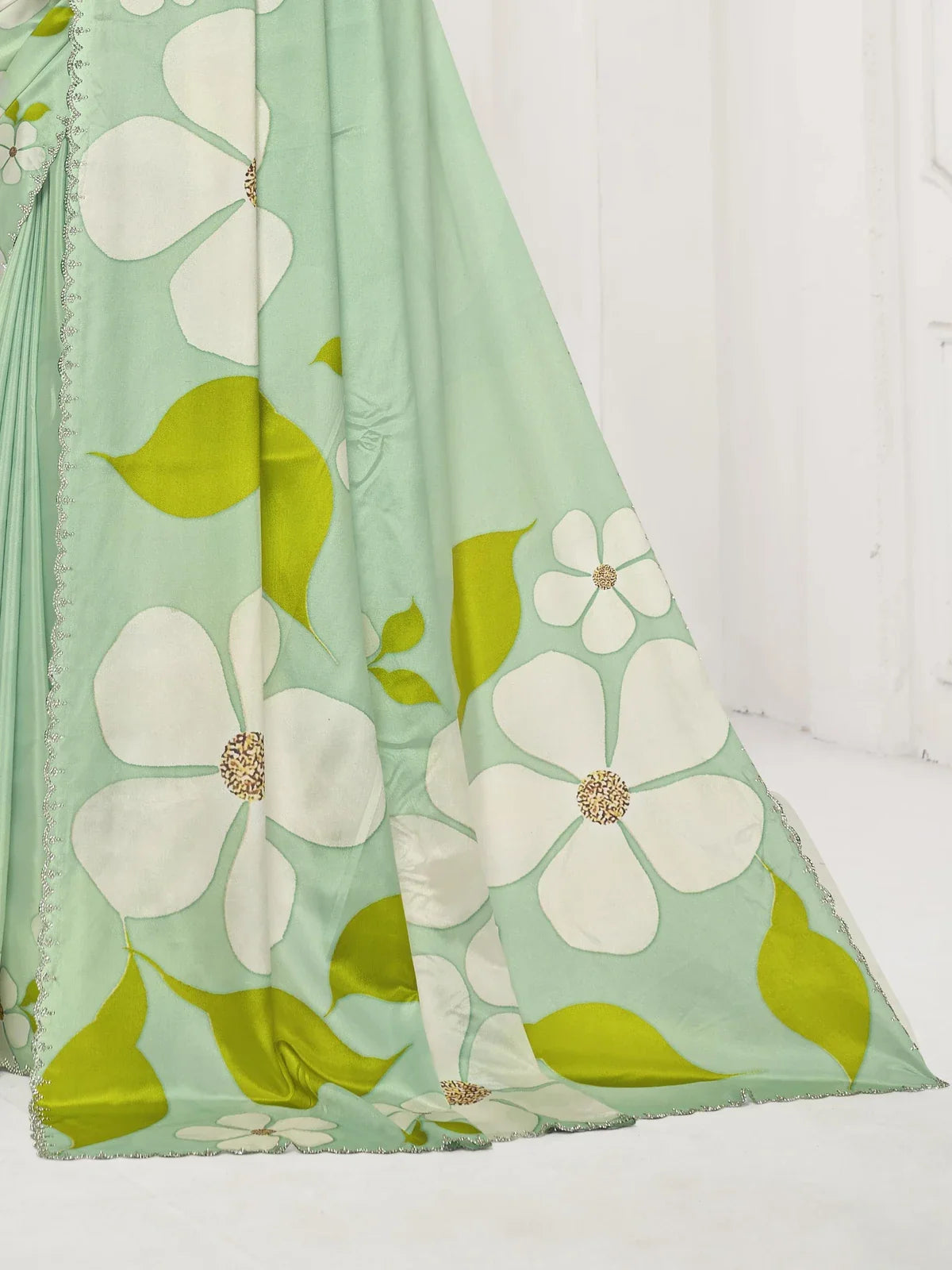 Tarani premium party wear saree in green with close-up of floral design and crystal embellished border