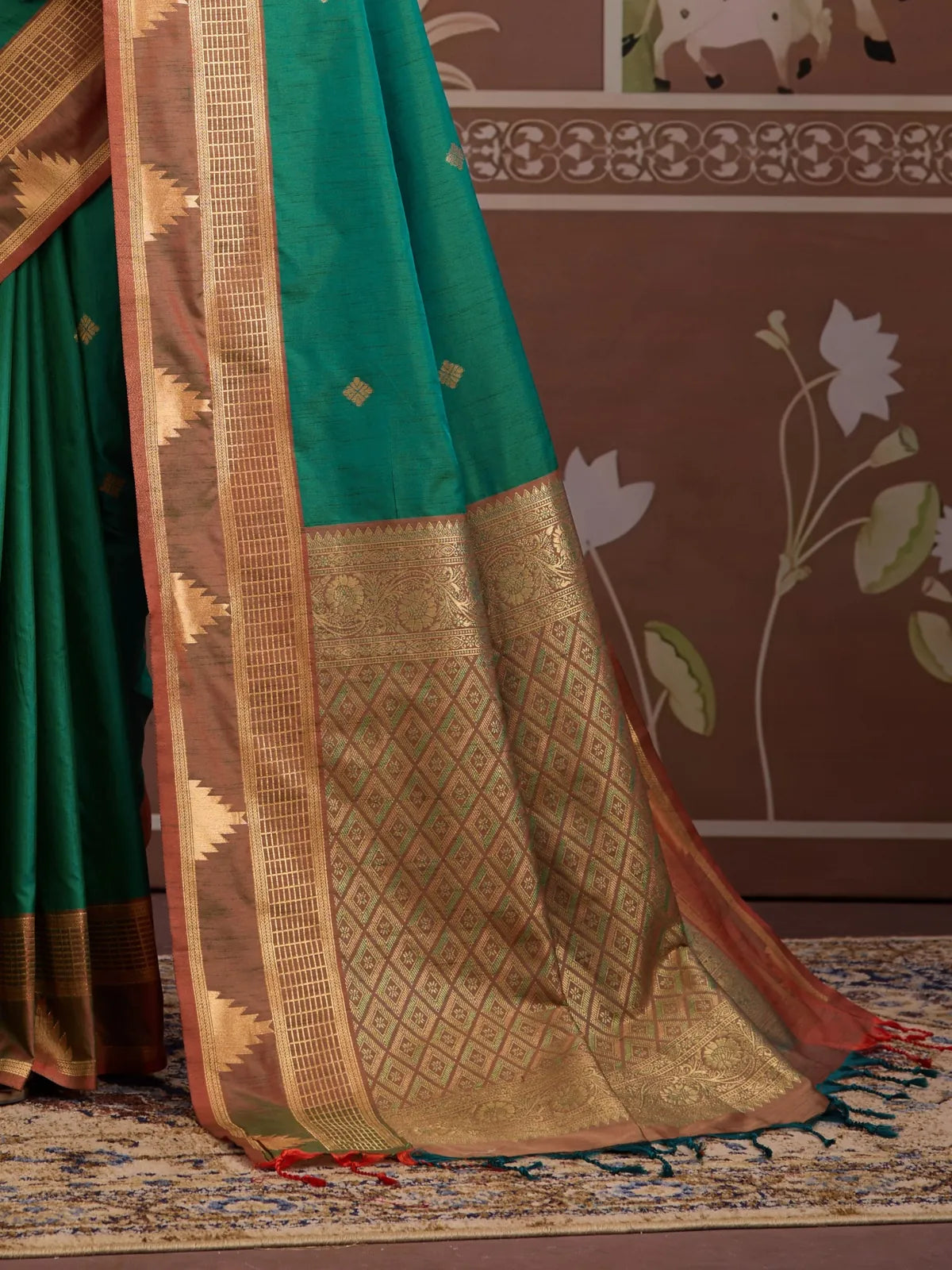Tarani green silk saree fabric closeup with golden motifs and copper border
