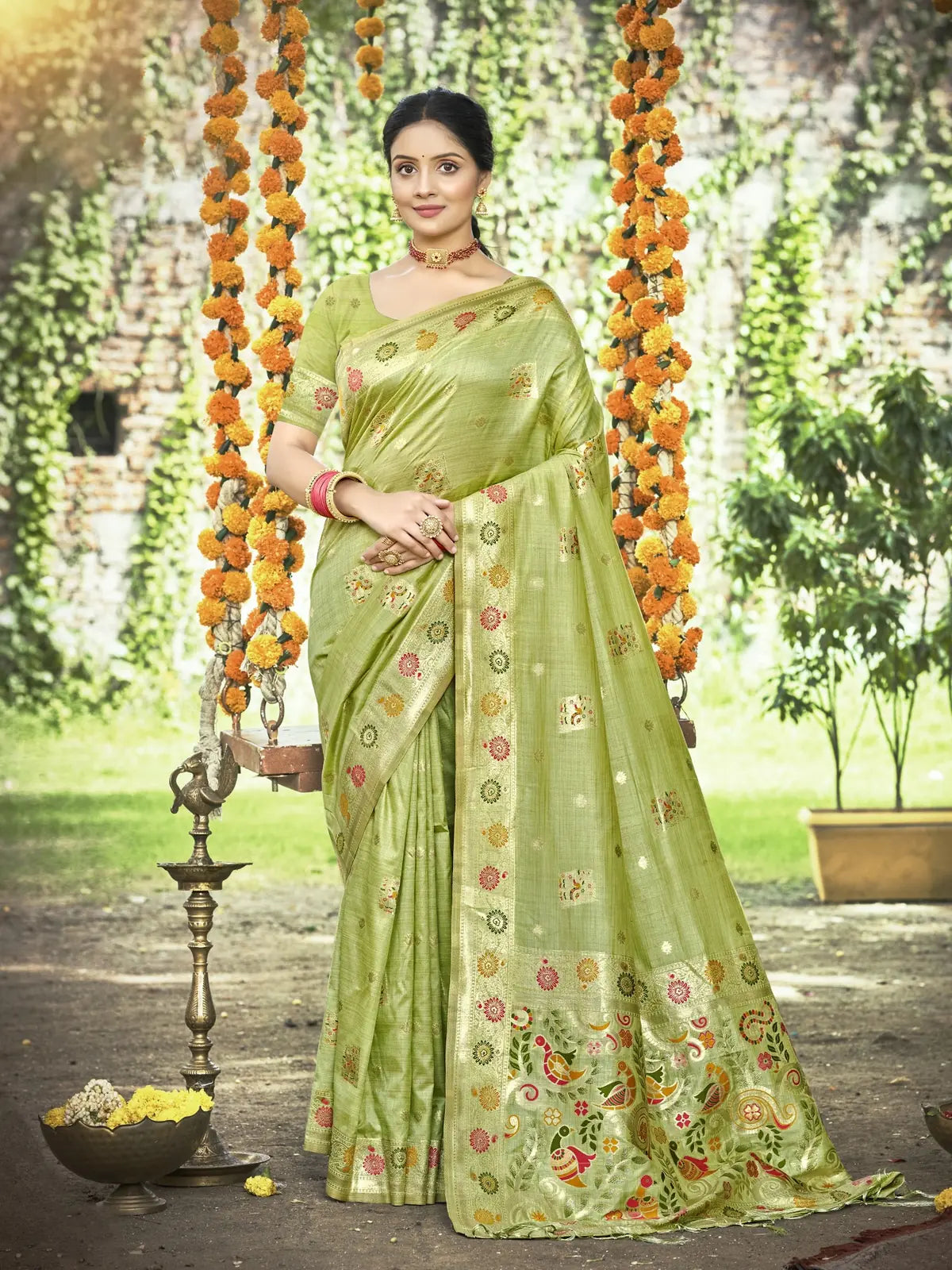 Tarani green Kanan silk saree full view with woven zari motifs and pallu border, model standing outdoors