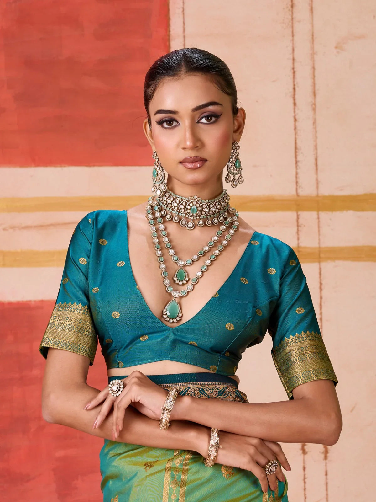 Tarani model wearing green silk saree with teal blouse and heavy necklace