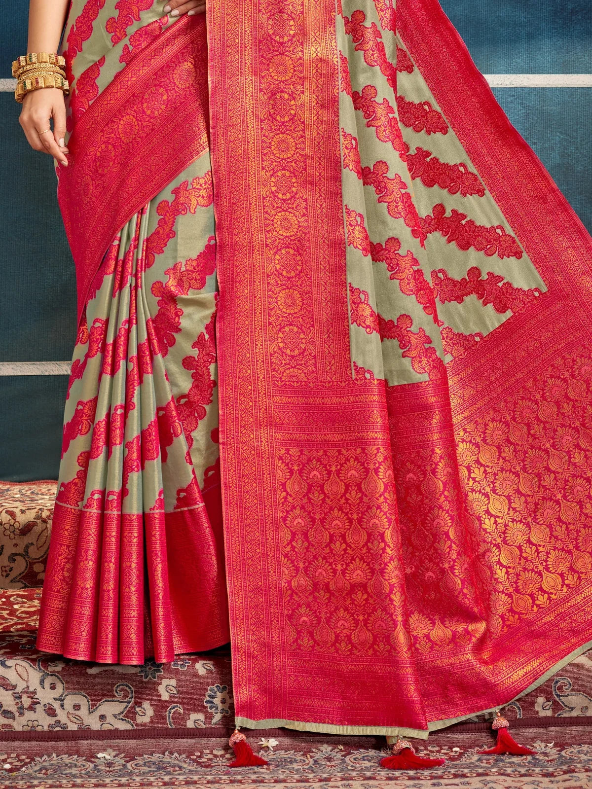 Tarani green silk saree pallu with rich red border and intricate zari design