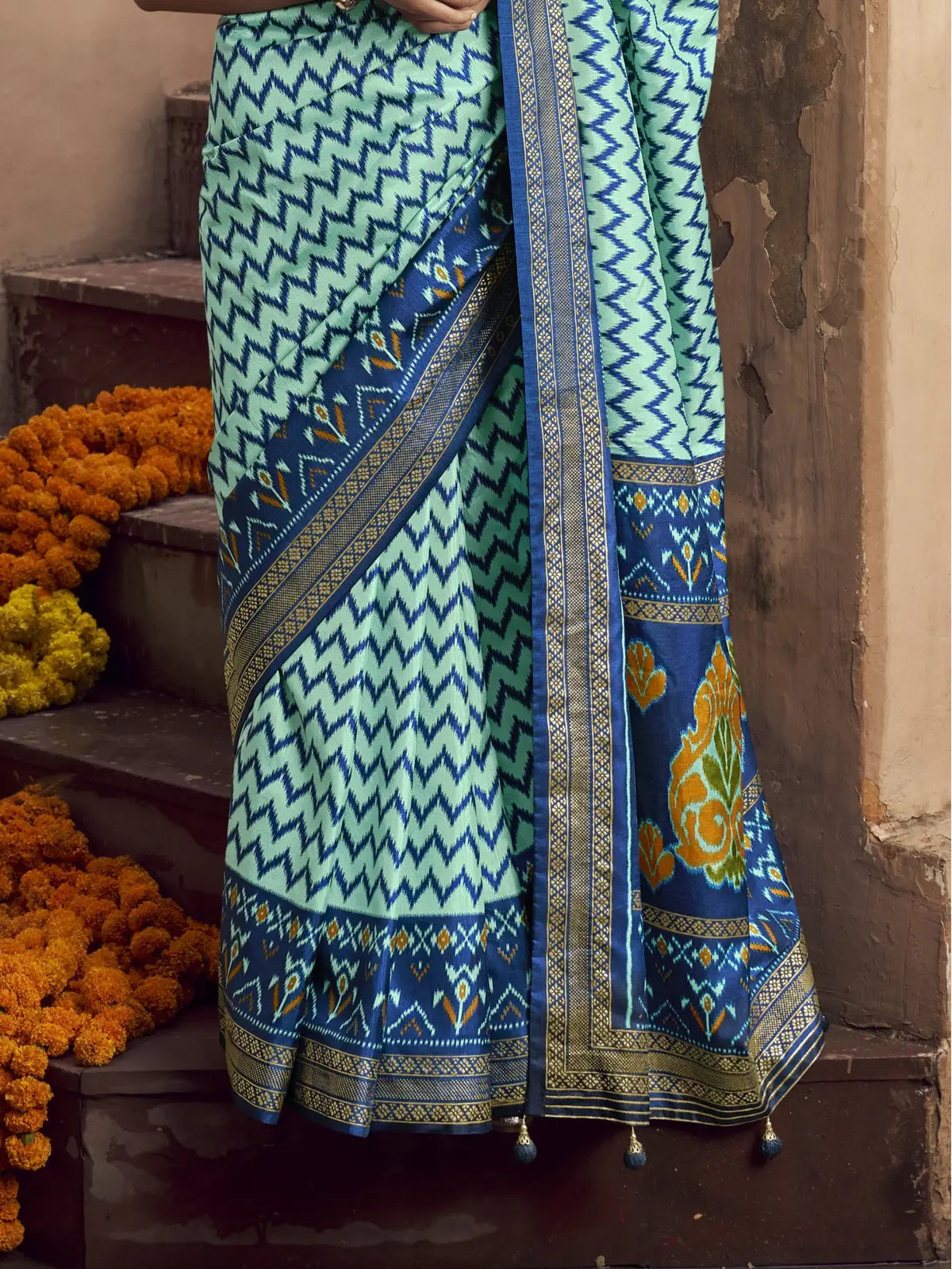 Tarani green silk saree pallu closeup with patola motifs and tassels on border