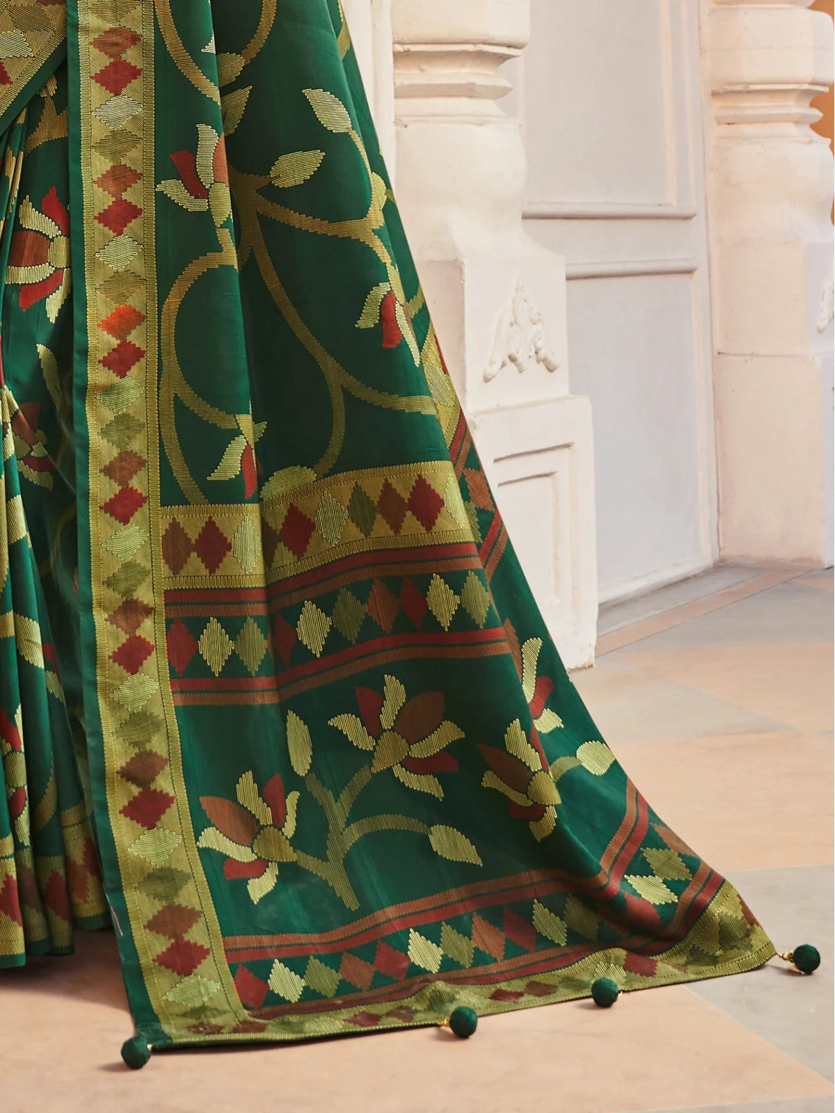 Tarani saree pallu with floral embroidery, mustard red pattern border and pom-pom finish detail