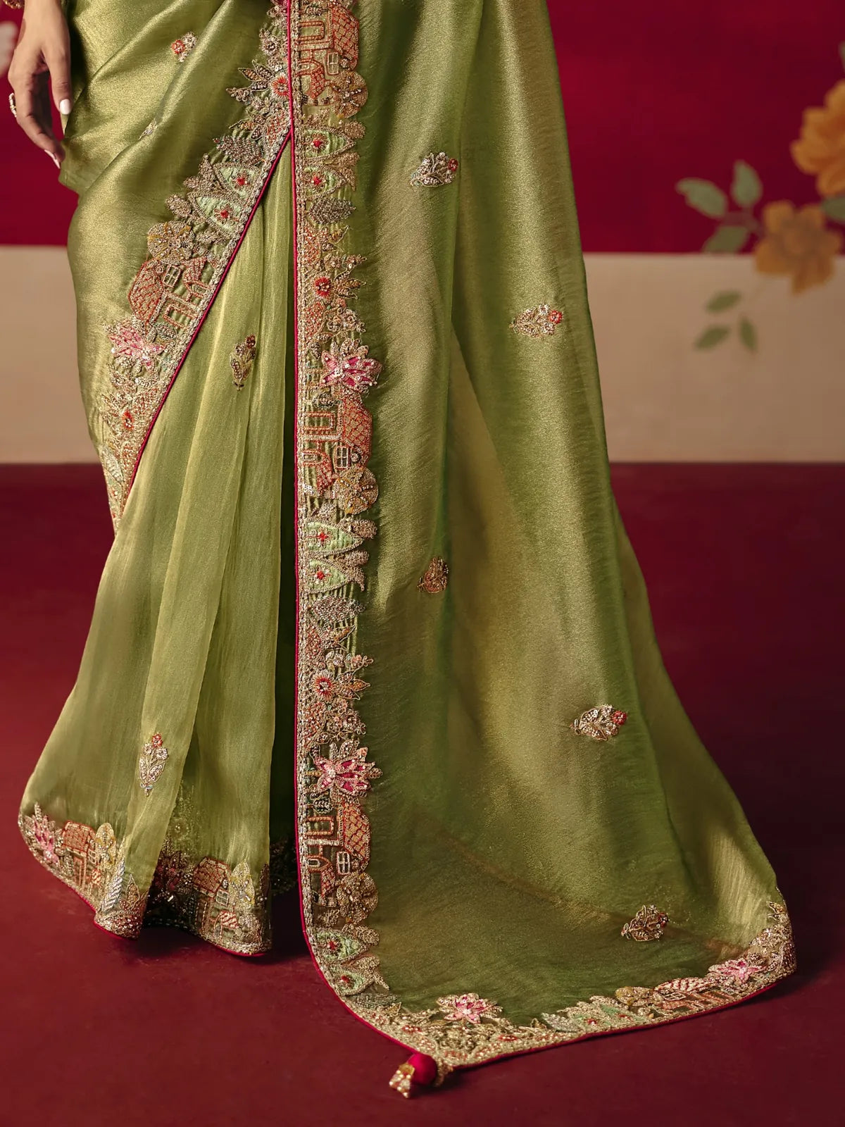 Tarani embroidered pallu and border close-up in green silk saree with pink detailing