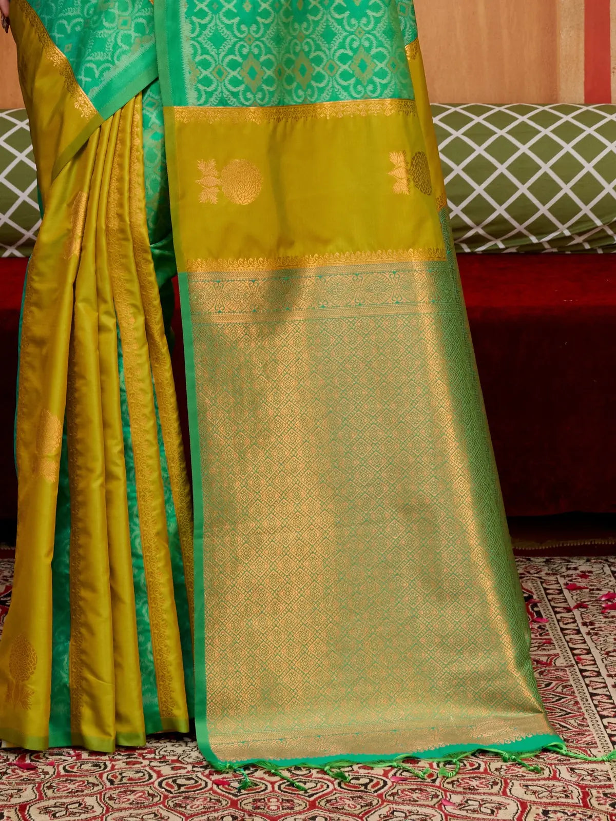 Tarani green silk saree pallu focus showing traditional motifs and golden weaving