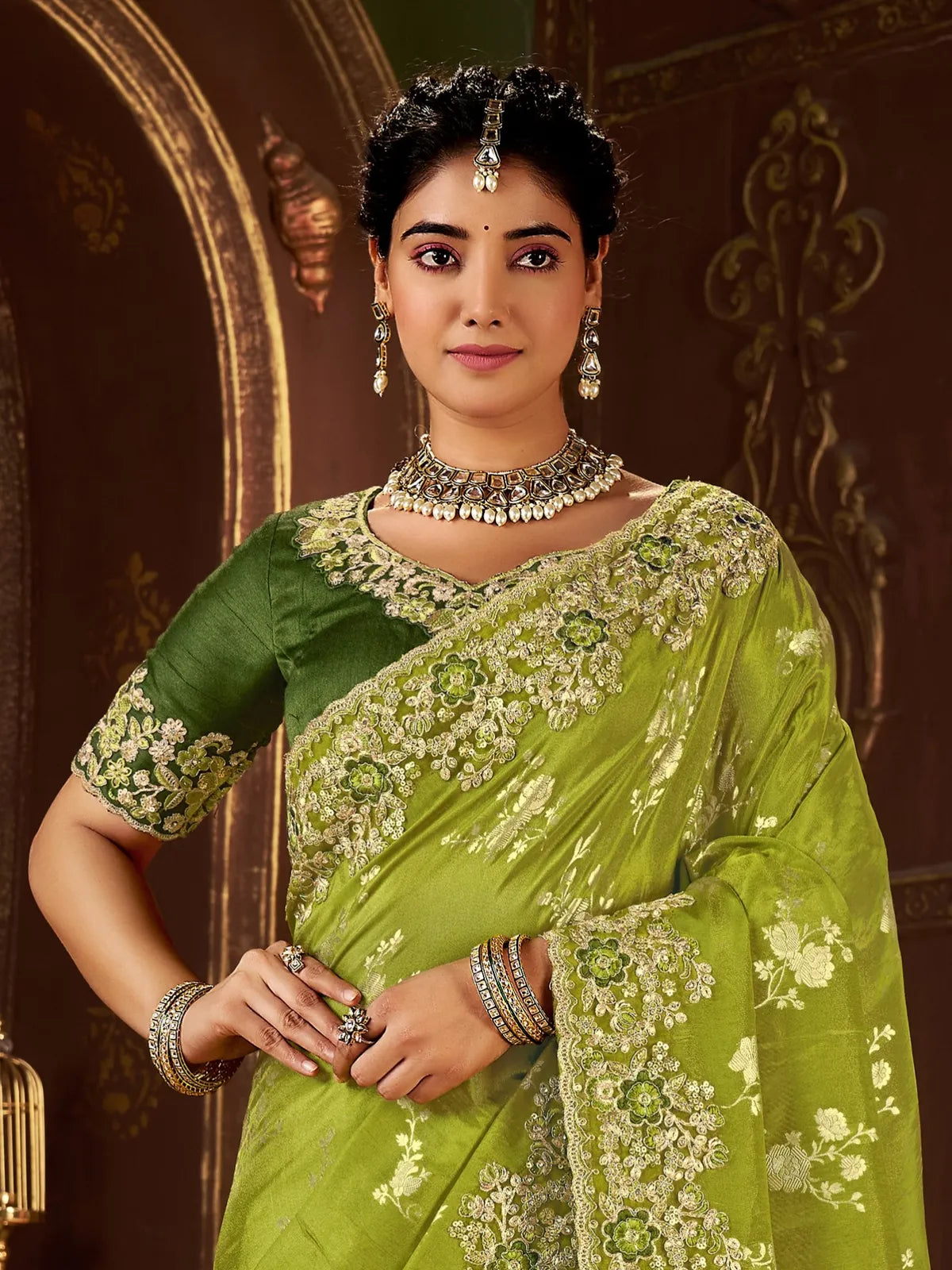 Tarani close-up upper body of green silk saree showing floral embroidery on blouse