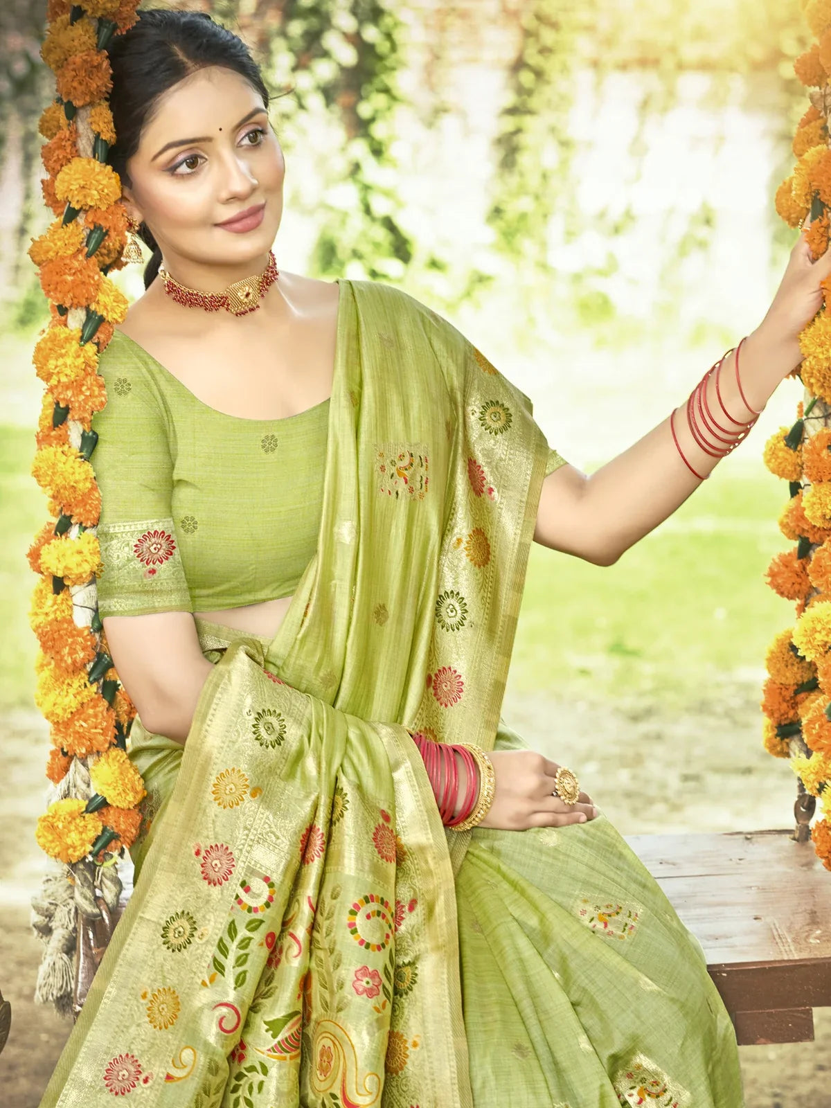 Tarani green Kanan silk saree upper body view with plain blouse and zari motifs, model on swing