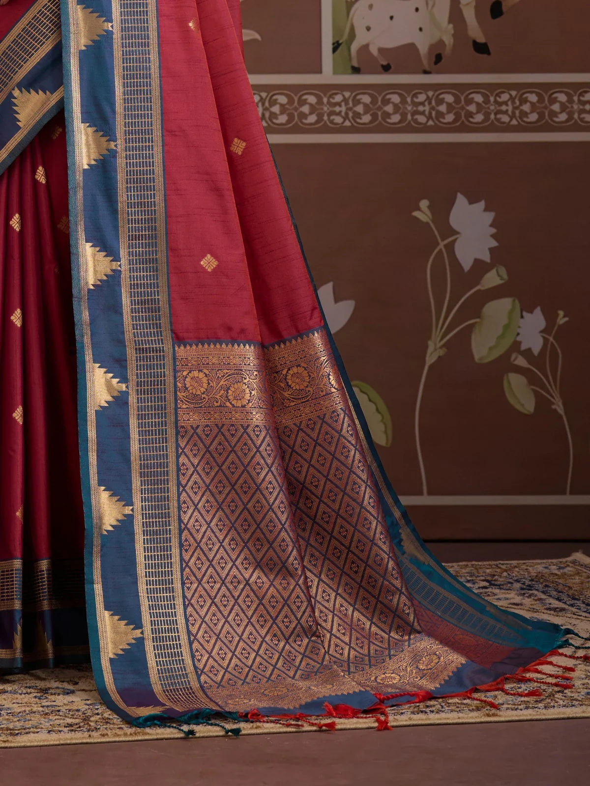 Tarani maroon saree pallu view showing intricate golden pattern and blue border