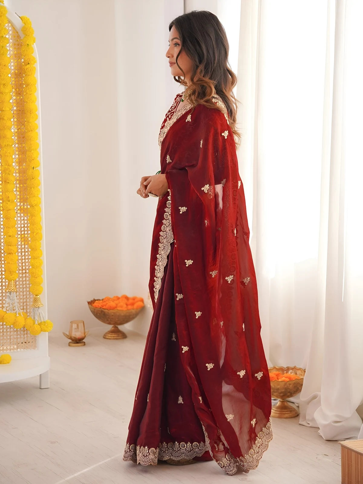 Tarani Mrunmayi maroon saree side view with flowing pallu and embroidered motifs
