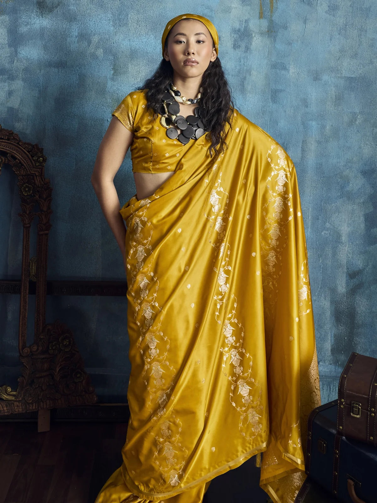 Tarani Nishika mustard satin saree pallu view highlighting rich woven border and tassels