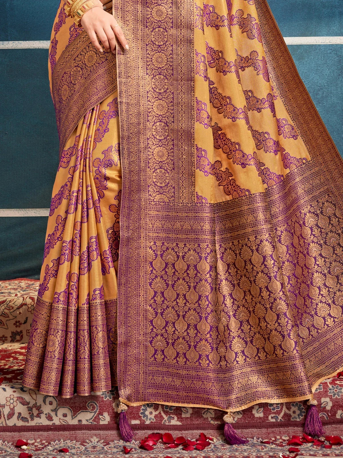 Tarani mustard silk saree close-up showing pallu and border with woven violet patterns and tassel edge