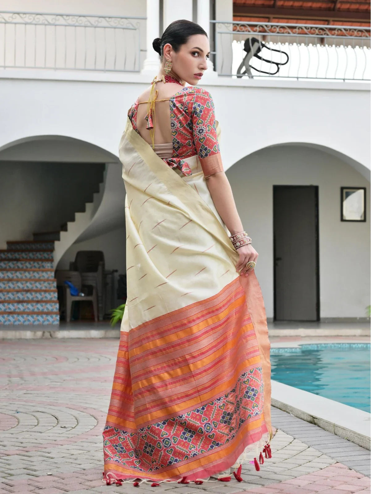 Tarani blouse back view in red multicolor ikkat paired with off white silk saree