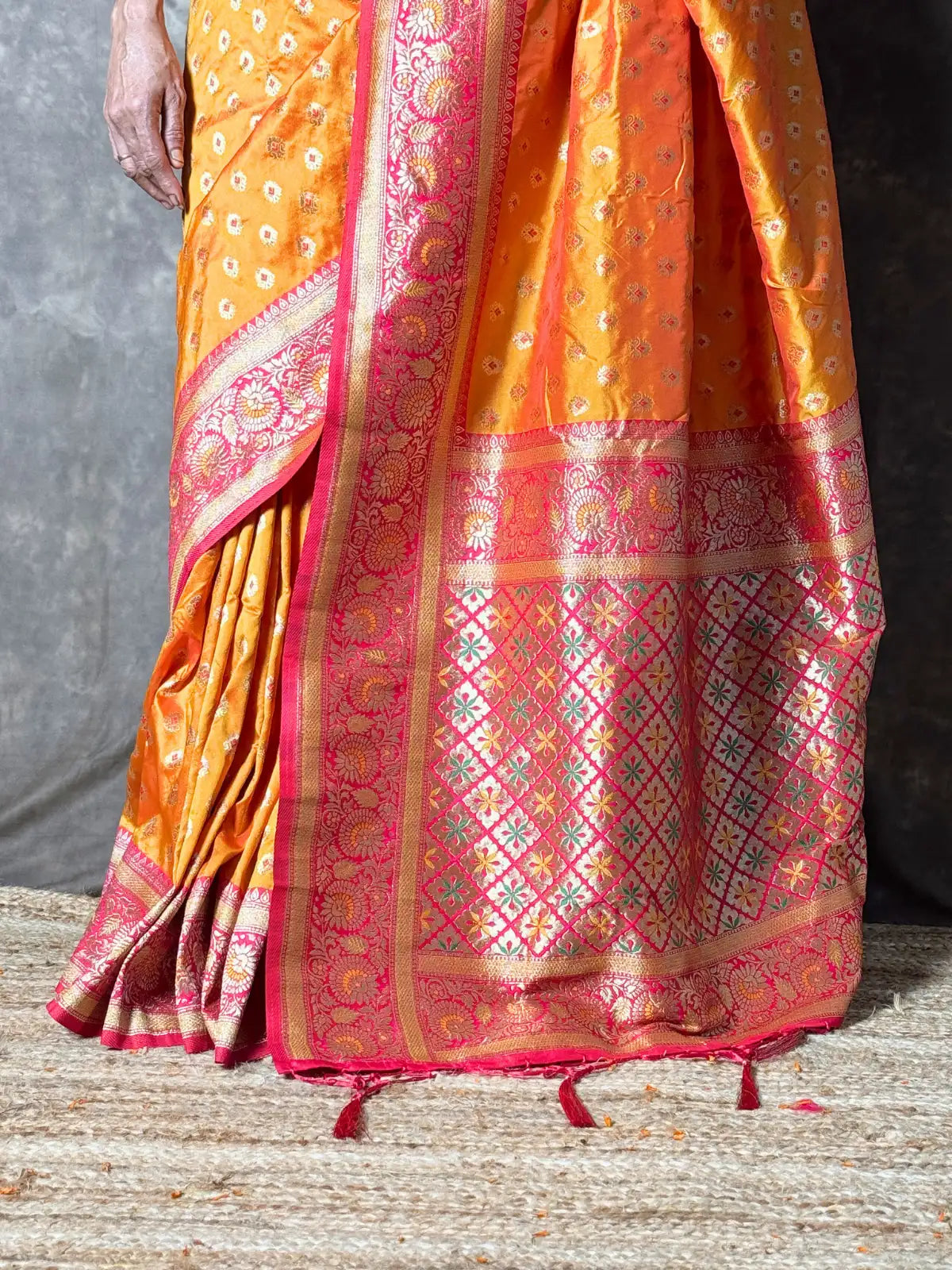 Tarani premium orange silk saree pallu view showcasing intricate woven detailing and zari border